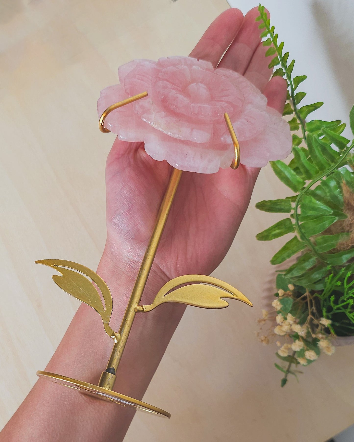 Rose Quartz flower crystal on metal stand, soft pink hues symbolizing unconditional love, heart healing, and emotional balance.