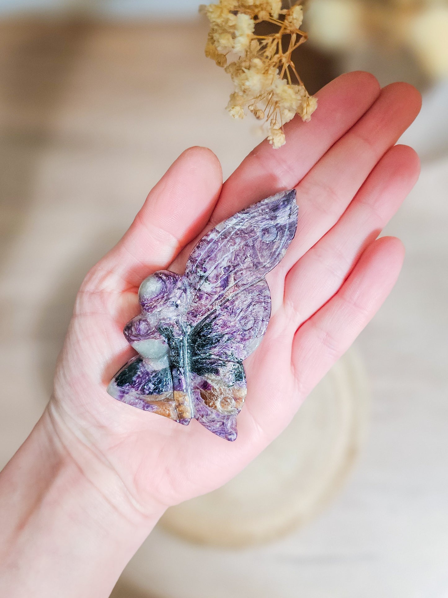 Charoite fairy carving in lavender to deep violet hues, showing intricate swirling patterns and delicate fairy shape