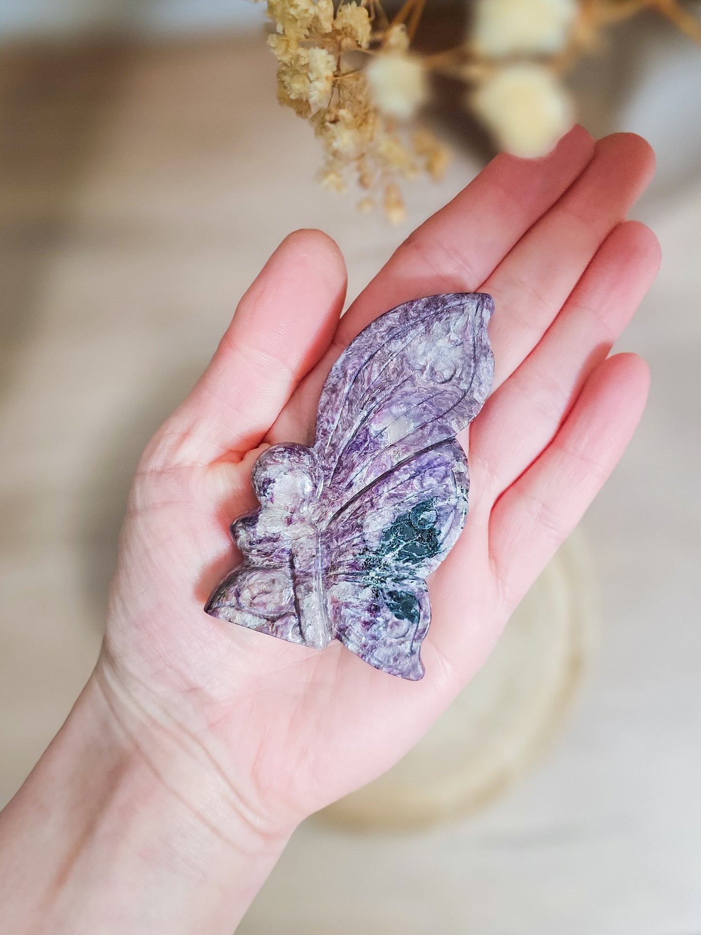Charoite fairy carving in lavender to deep violet hues, showing intricate swirling patterns and delicate fairy shape