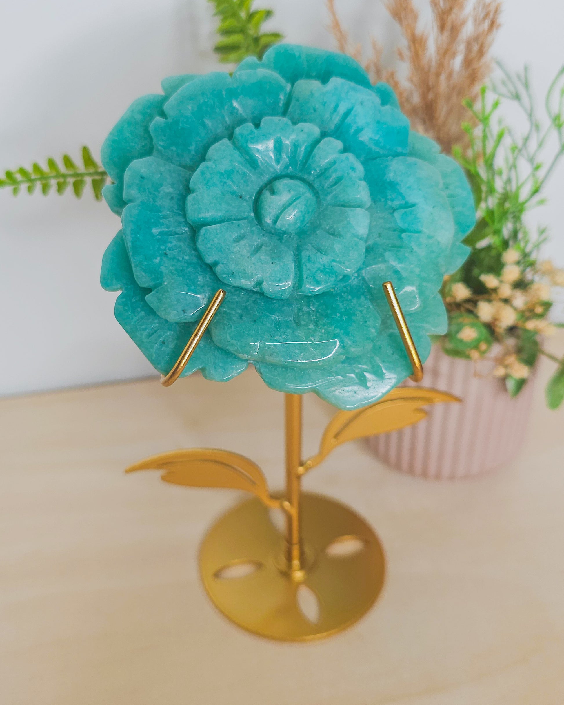 Amazonite flower crystal on metal stand, blue-green tones with petal details, symbolizing emotional balance and spiritual growth.
