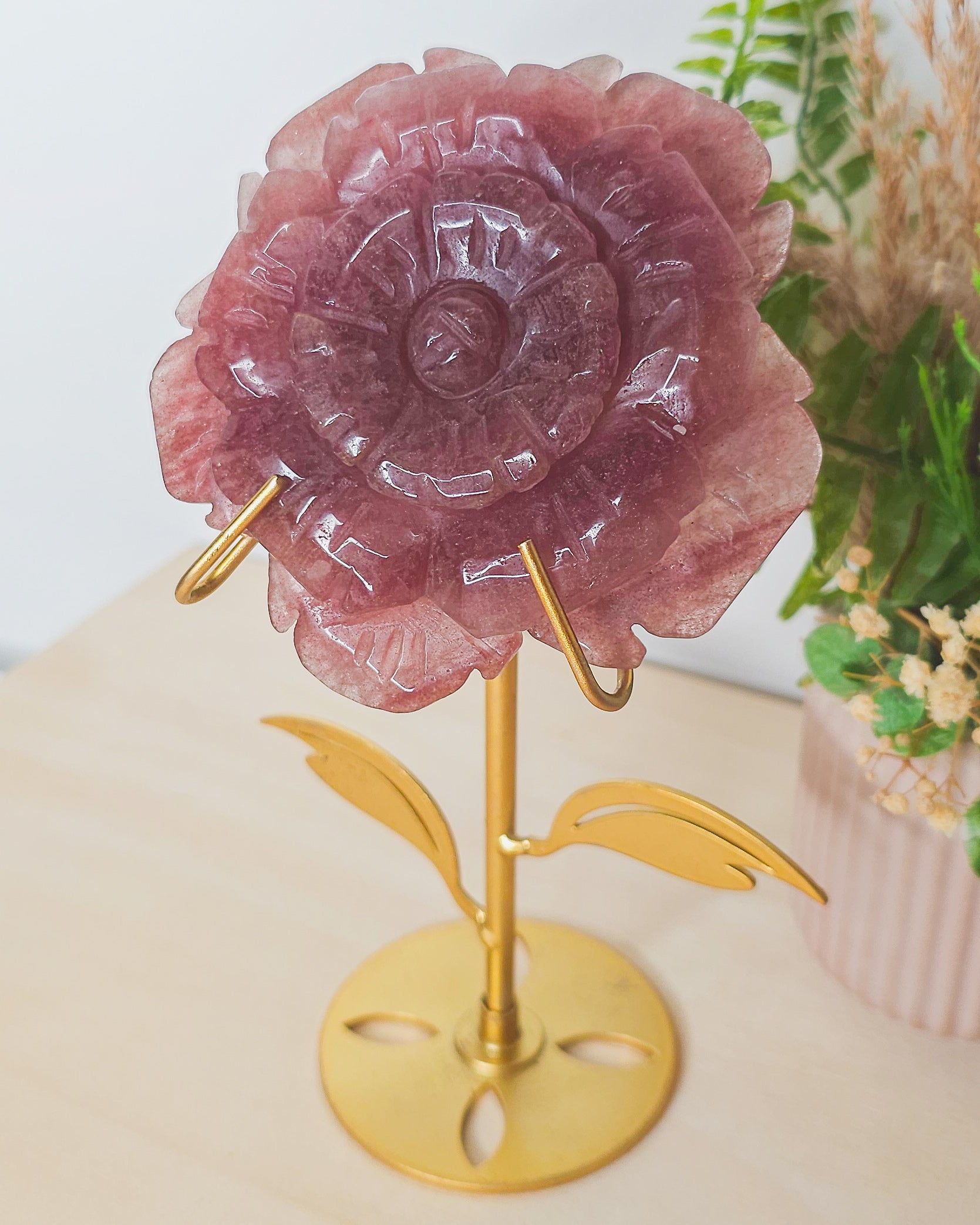 Close-up of Strawberry Quartz flower carving showing shimmery inclusions and petal details, representing heart expansion and joyful energy.
