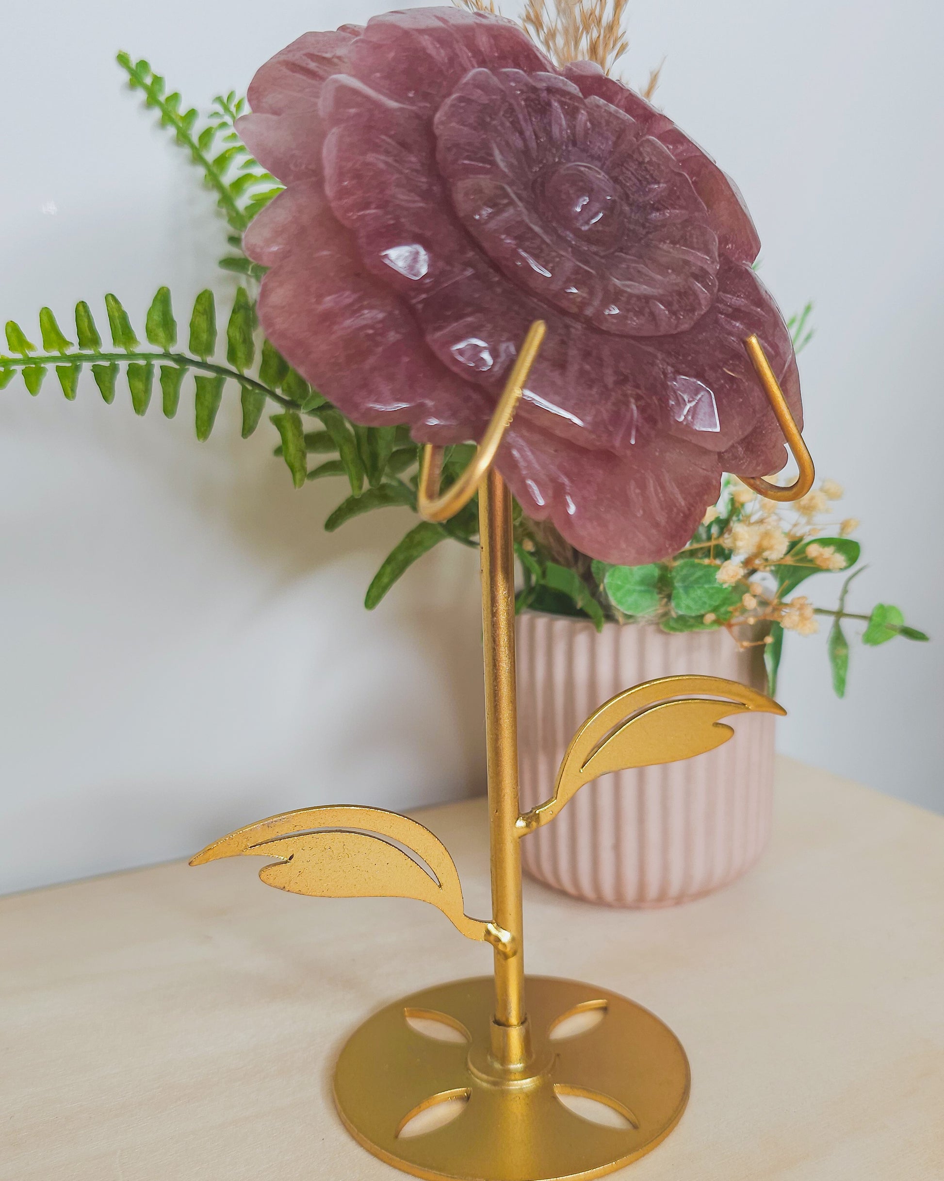 Close-up of Strawberry Quartz flower carving showing shimmery inclusions and petal details, representing heart expansion and joyful energy.
