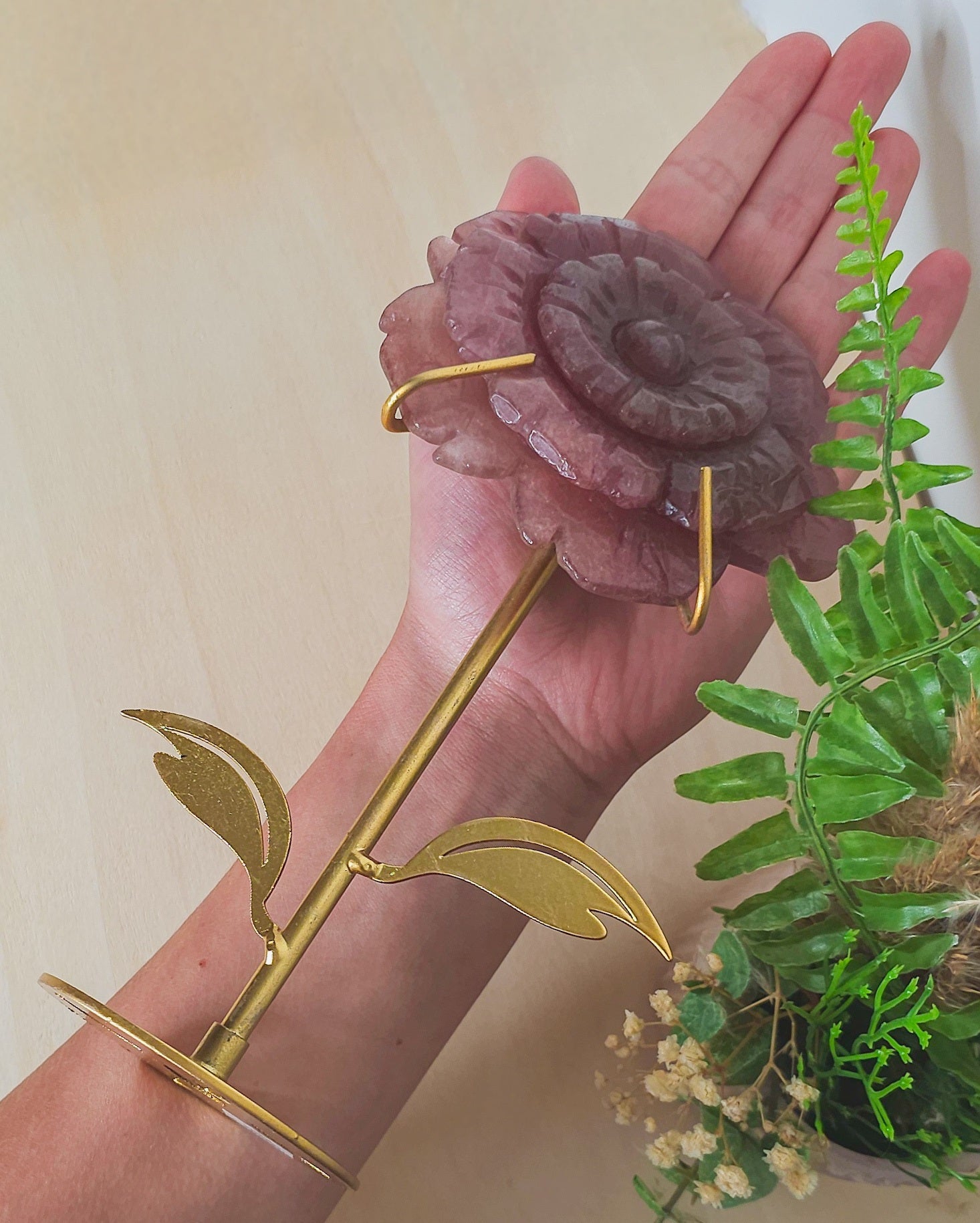 Close-up of Strawberry Quartz flower carving showing shimmery inclusions and petal details, representing heart expansion and joyful energy.
