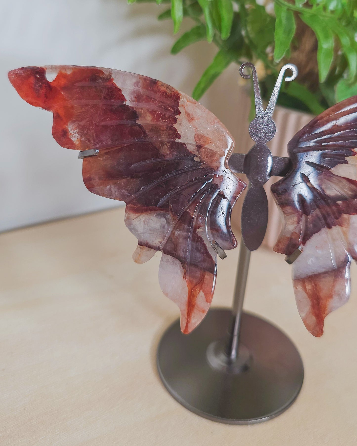 Close-up of Fire Quartz butterfly wing showing fiery inclusions inside transparent quartz, representing clarity, empowerment, and emotional alchemy.