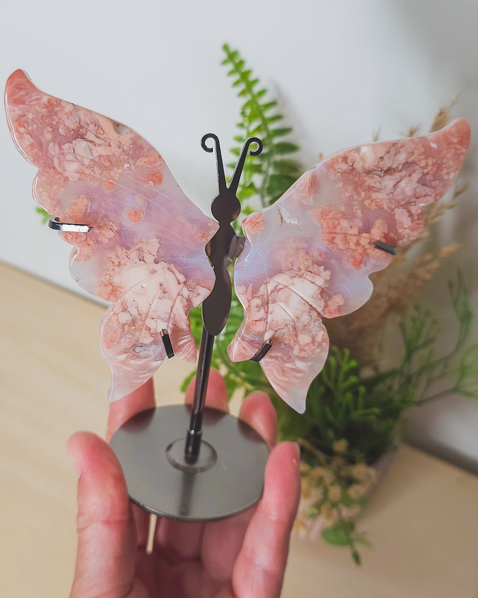  view of the Cotton Candy Agate wings on stand, showcasing the natural patterns and symmetrical shape of the carved wings