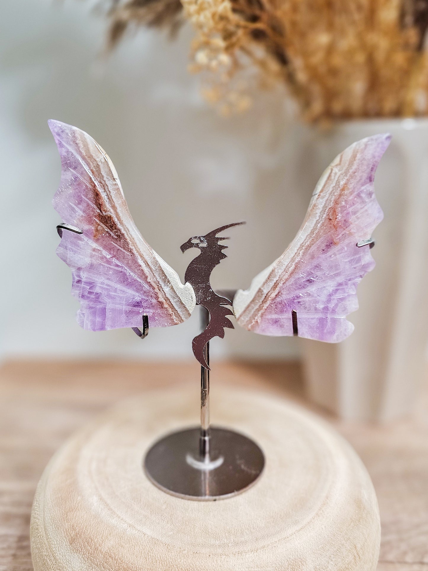 Violet amethyst dragon wings, carved with intricate detail, showing natural banding and crystal texture