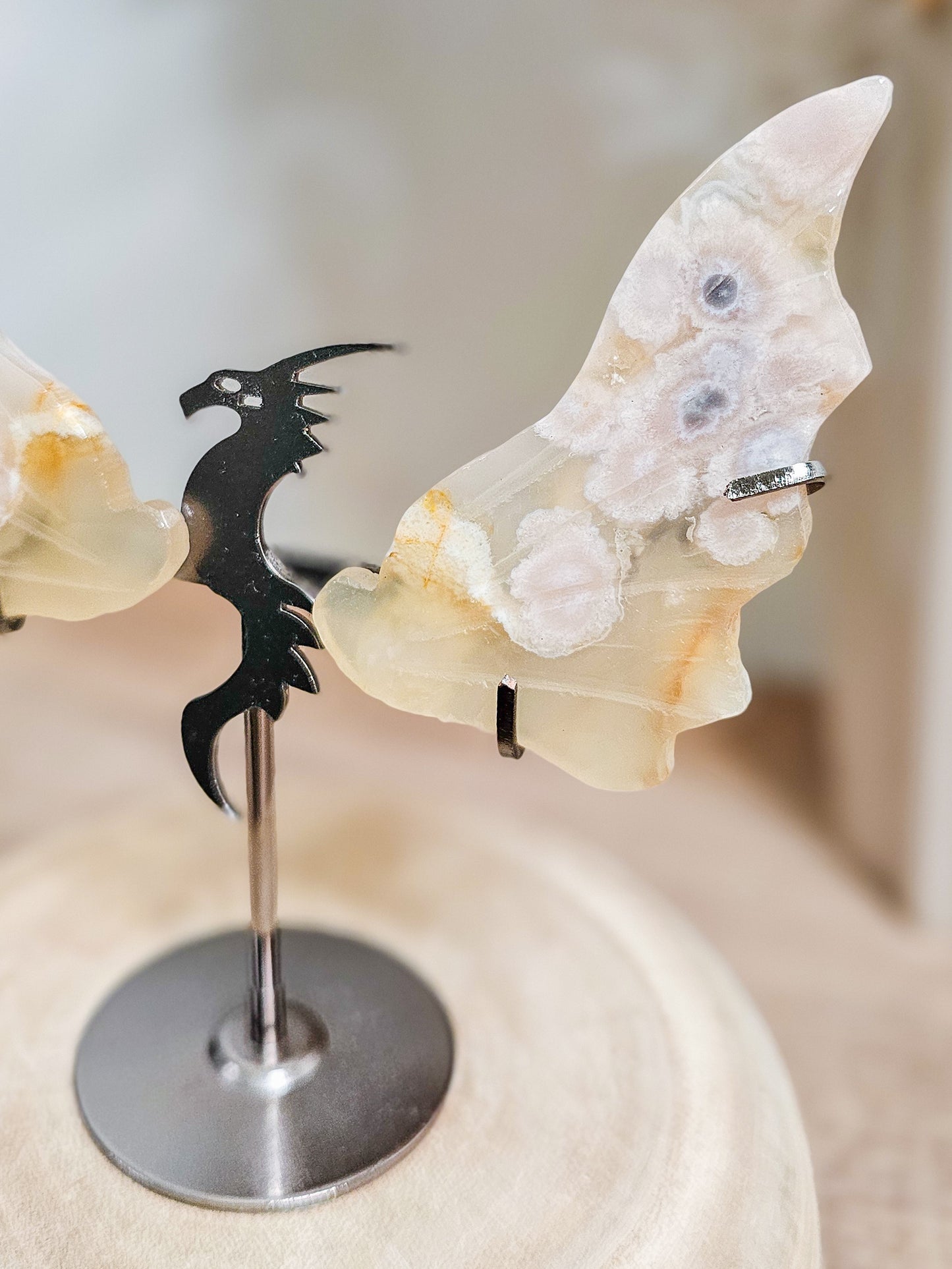 Close-up of carved Flower Agate dragon wings, showing intricate crystal texture and subtle fluorescence under light