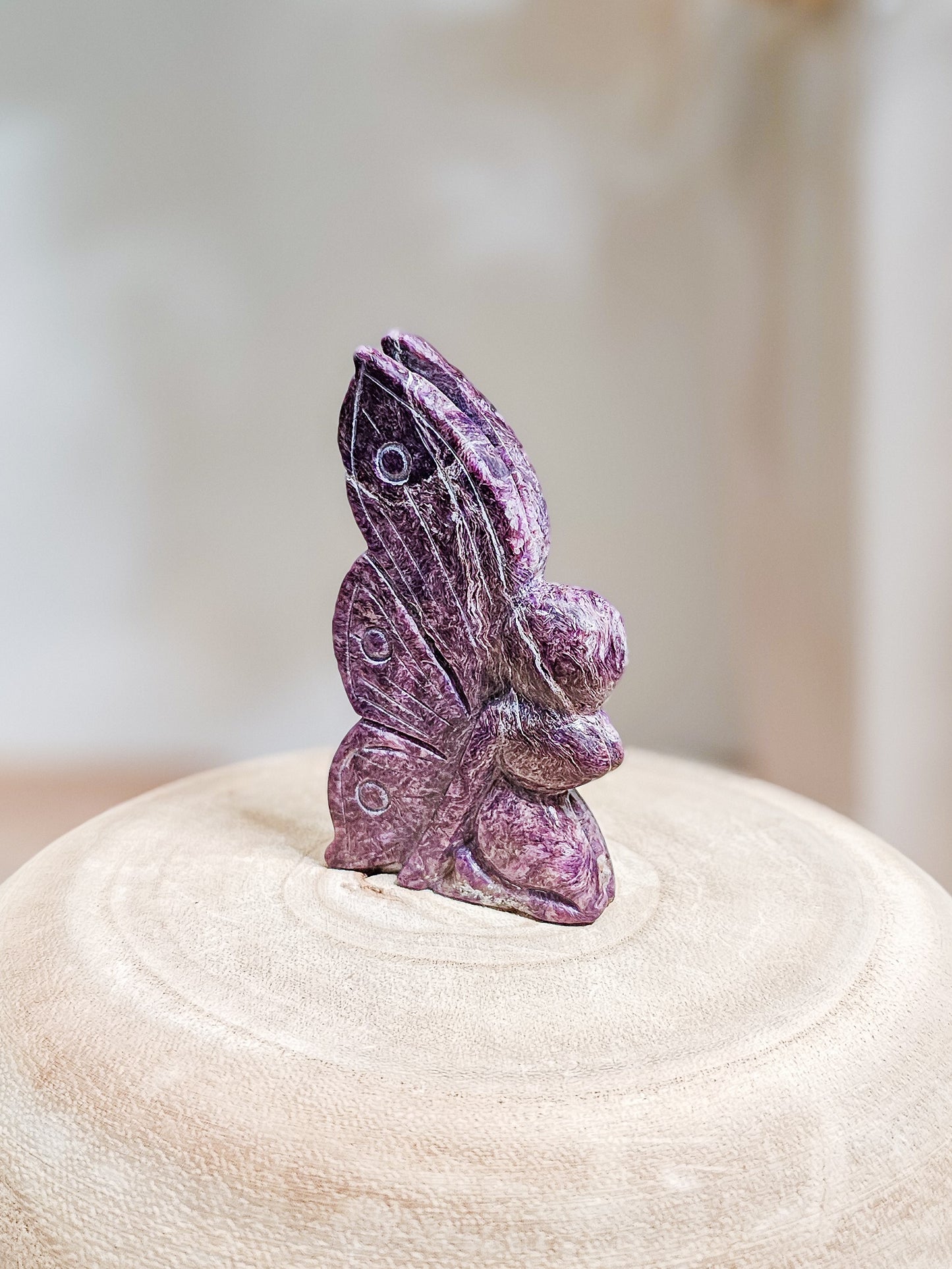 Purple Charoite fairy carving with smooth polished surface, showcasing natural chatoyant patterns