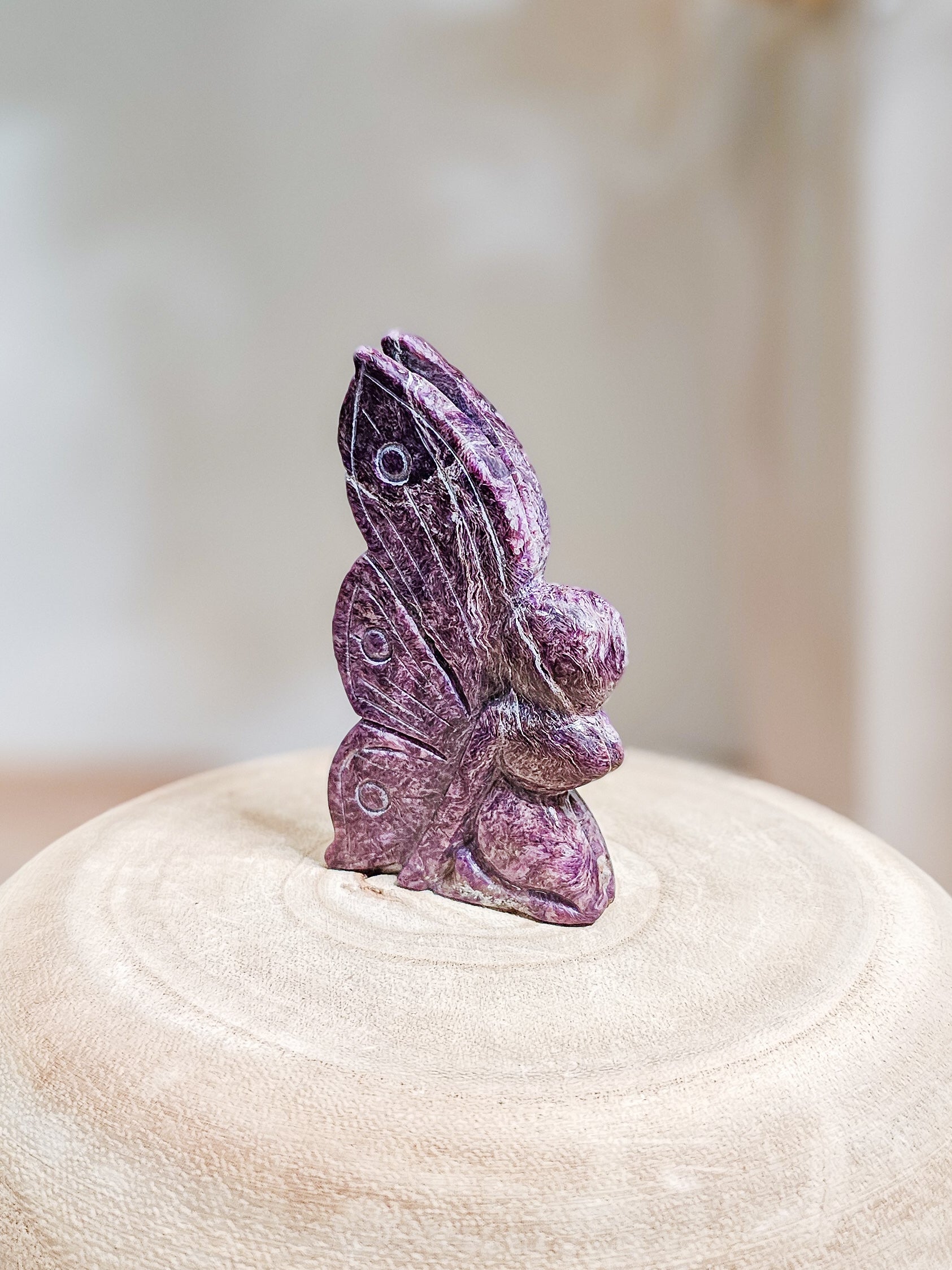 Purple Charoite fairy carving with smooth polished surface, showcasing natural chatoyant patterns