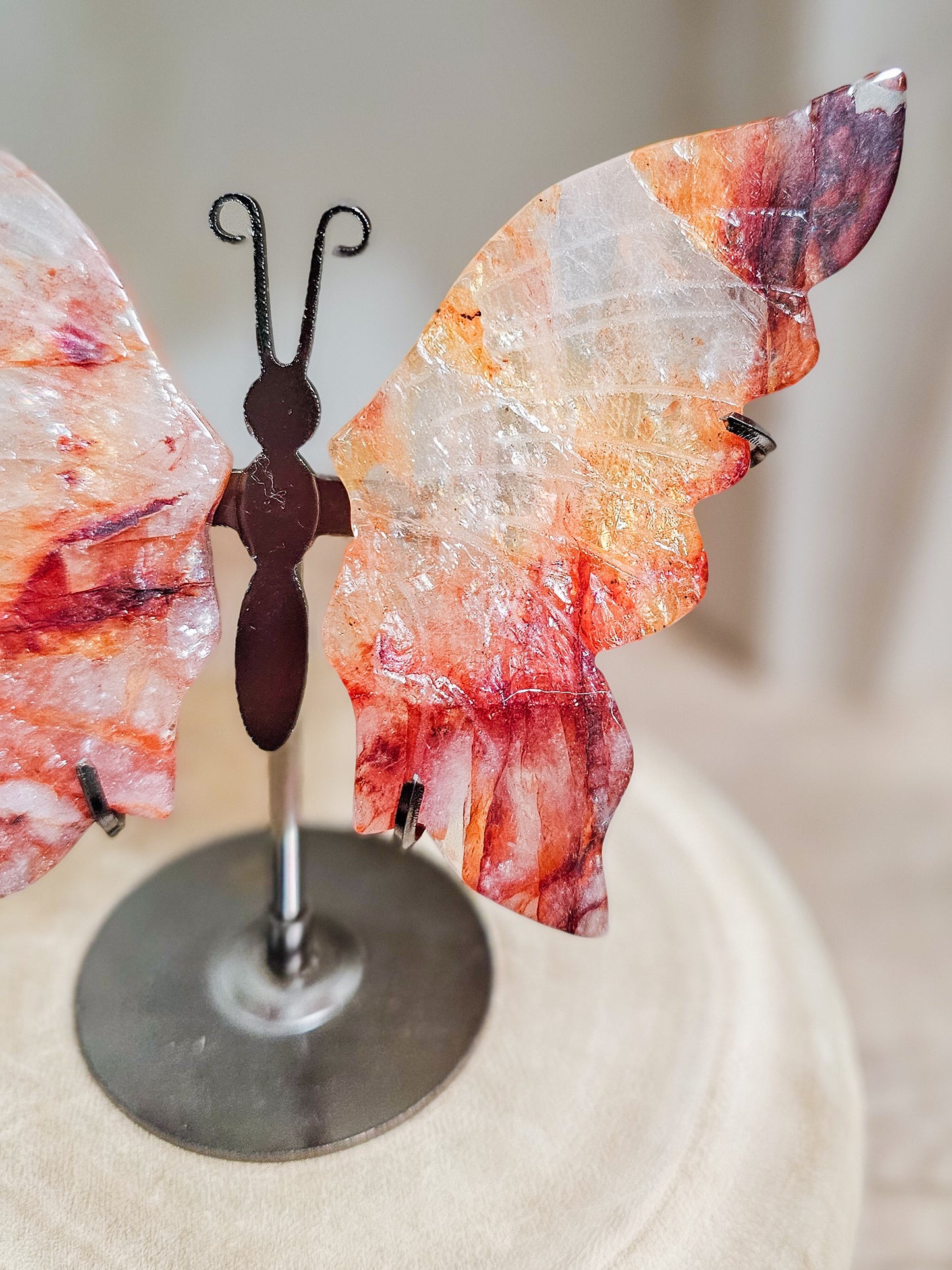 Butterfly-shaped crystal on a stand with a blurred background