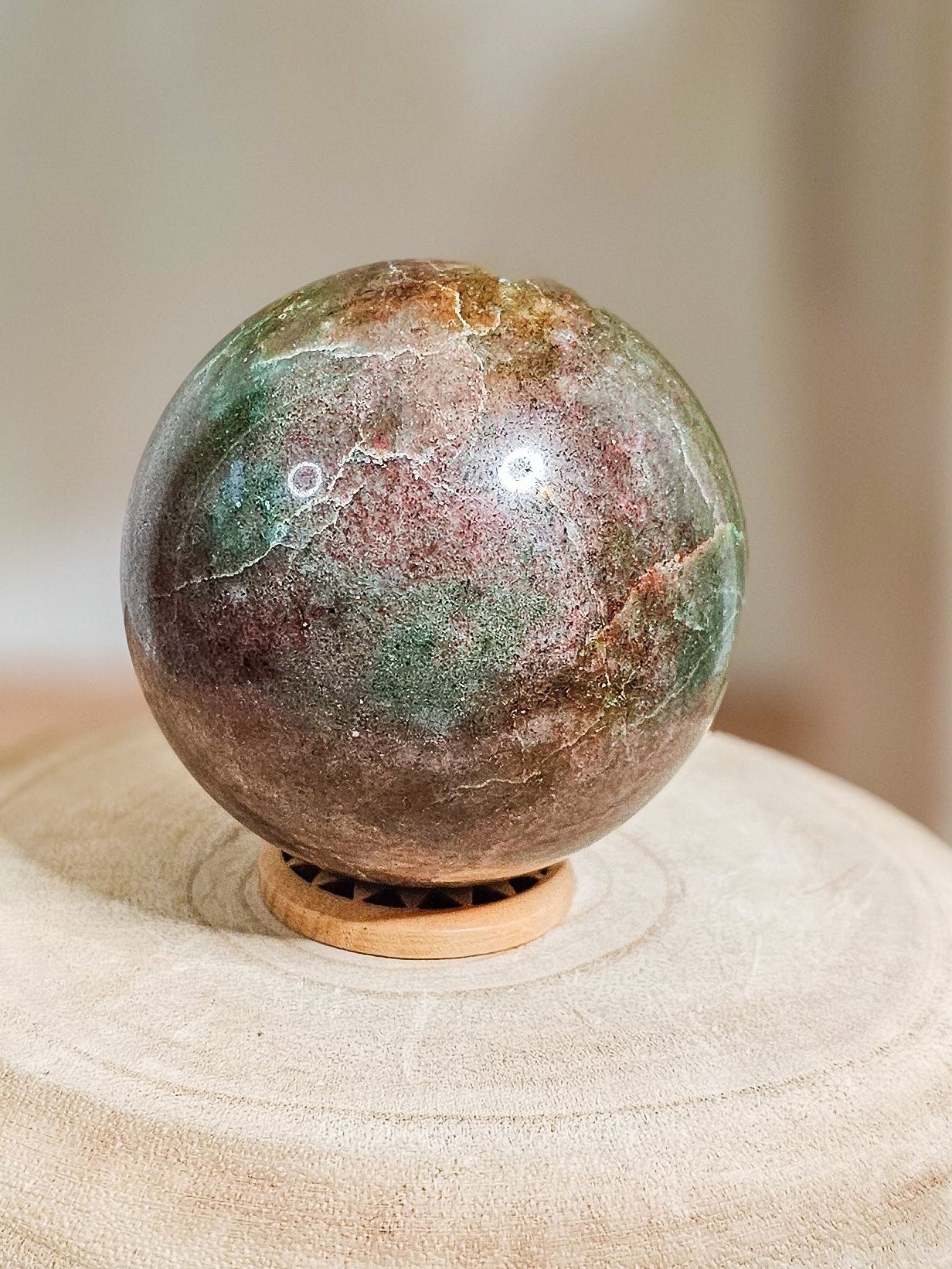 Eclogite sphere polished from garnet and omphacite metamorphic rock, deep green matrix with red garnet inclusions