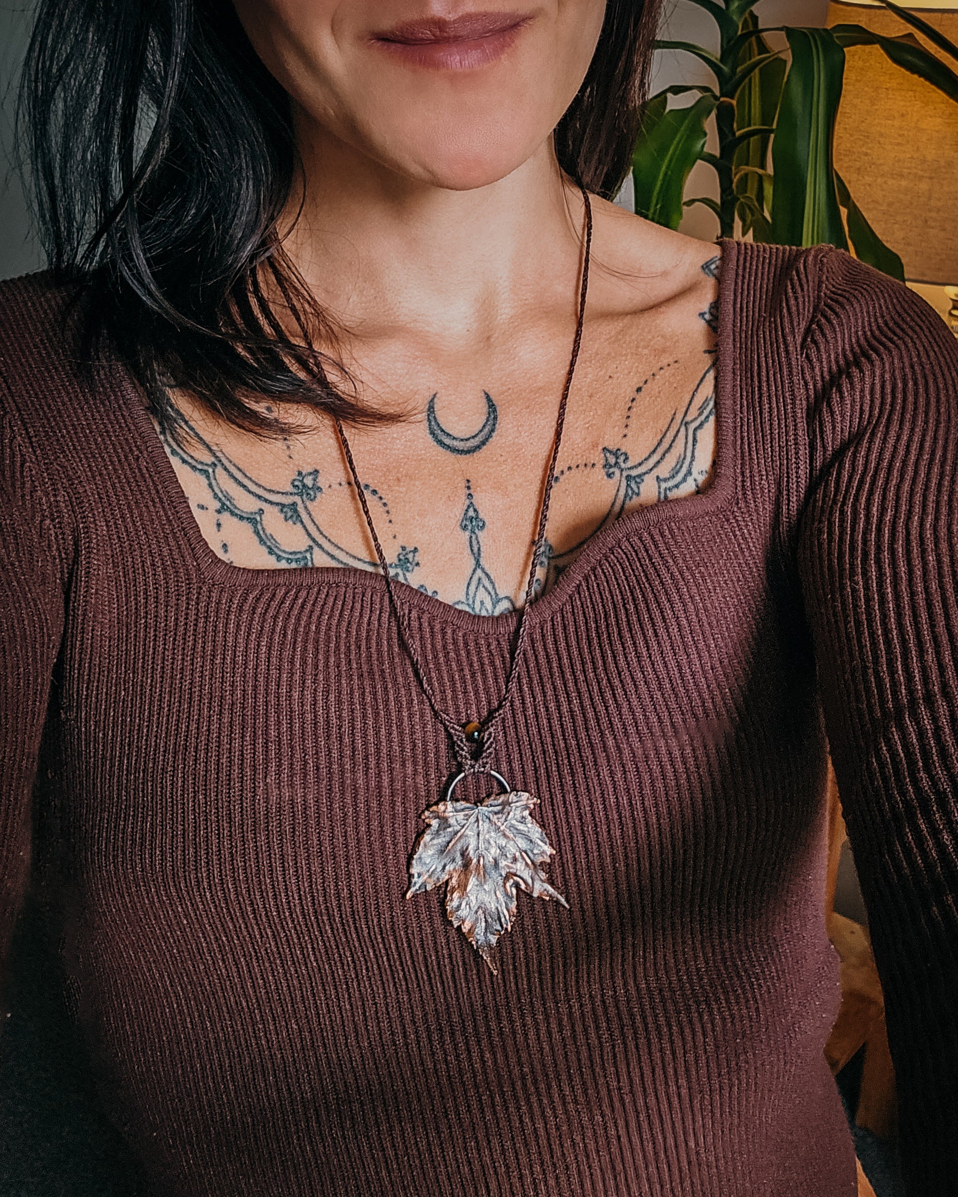 Person wearing a Handmade Copper electroformed Necklace with maple leaf pendant, macrame and Tiger's Eye bead 