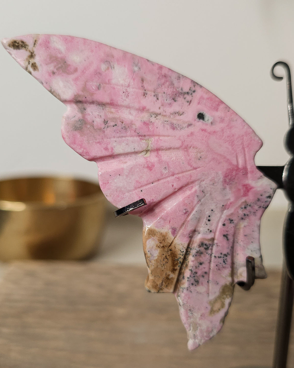 Peruvian Rhodonite crystal butterfly wings on a metal stand, with unique pink and dark markings. A meaningful gift or addition to your crystal collection.