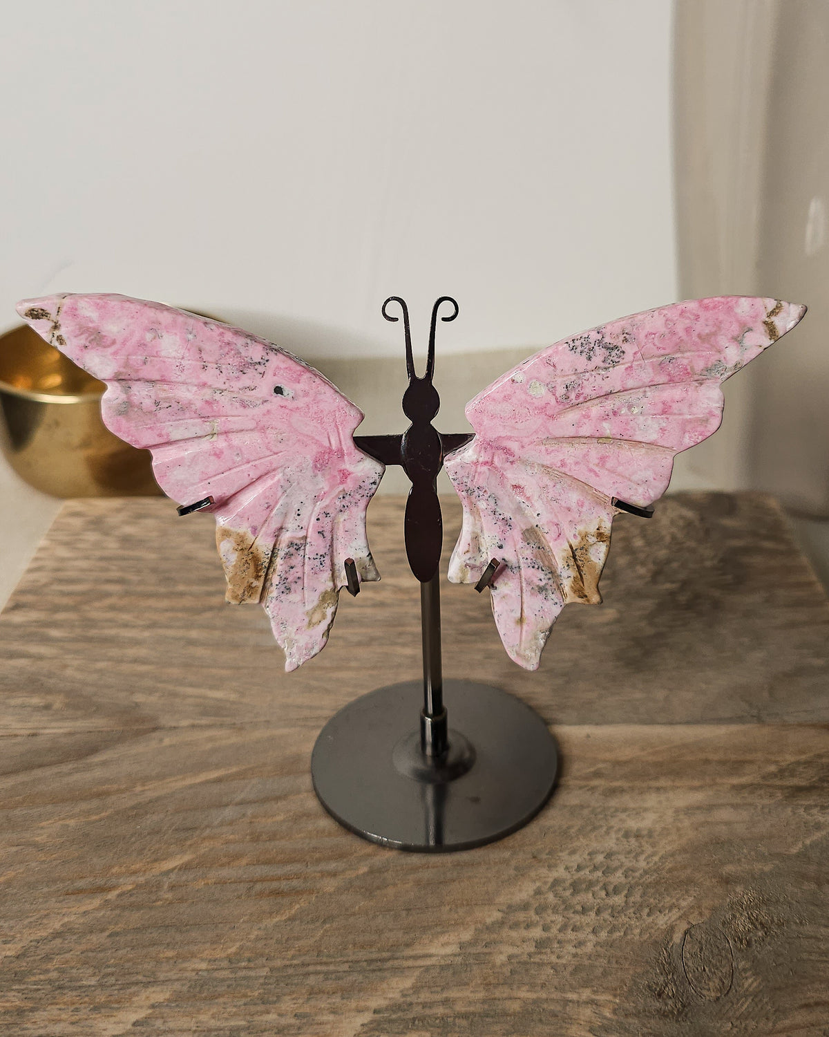 Peruvian Rhodonite crystal butterfly wings on a metal stand, with unique pink and dark markings. A meaningful gift or addition to your crystal collection.