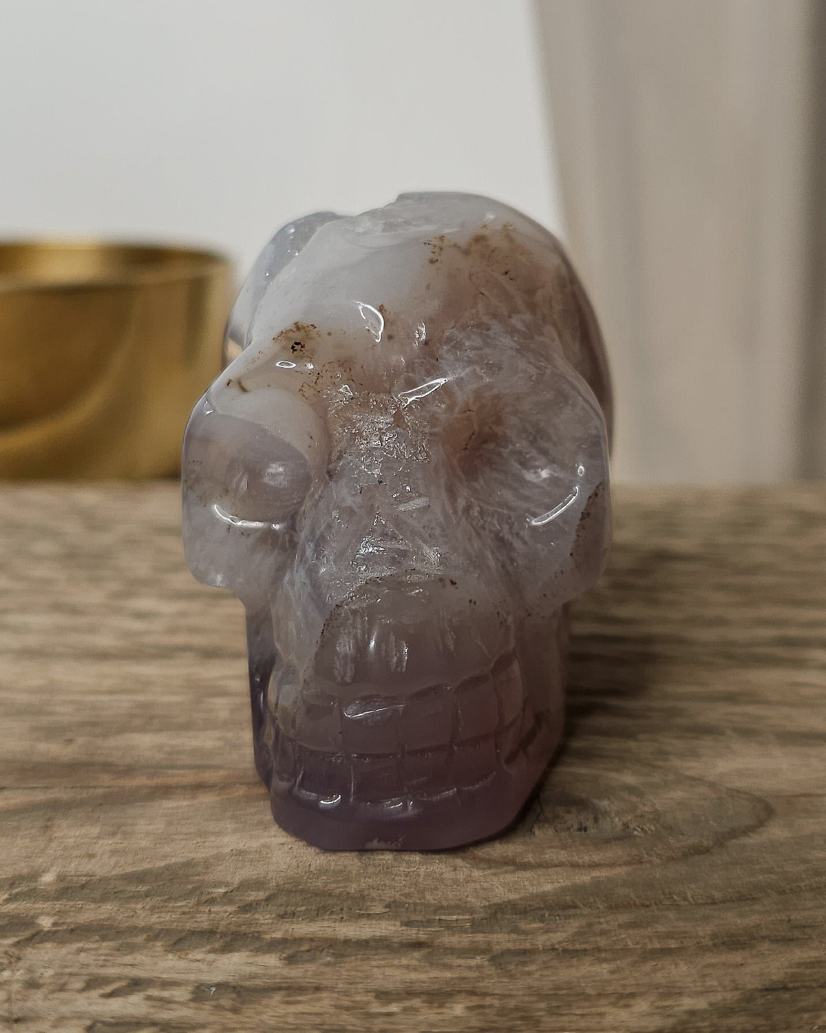 Druzy Agate crystal skull carving with translucent grey and lavender bands, deep purple areas, natural brown inclusions and a sparkling druzy crystal cavity on top.
