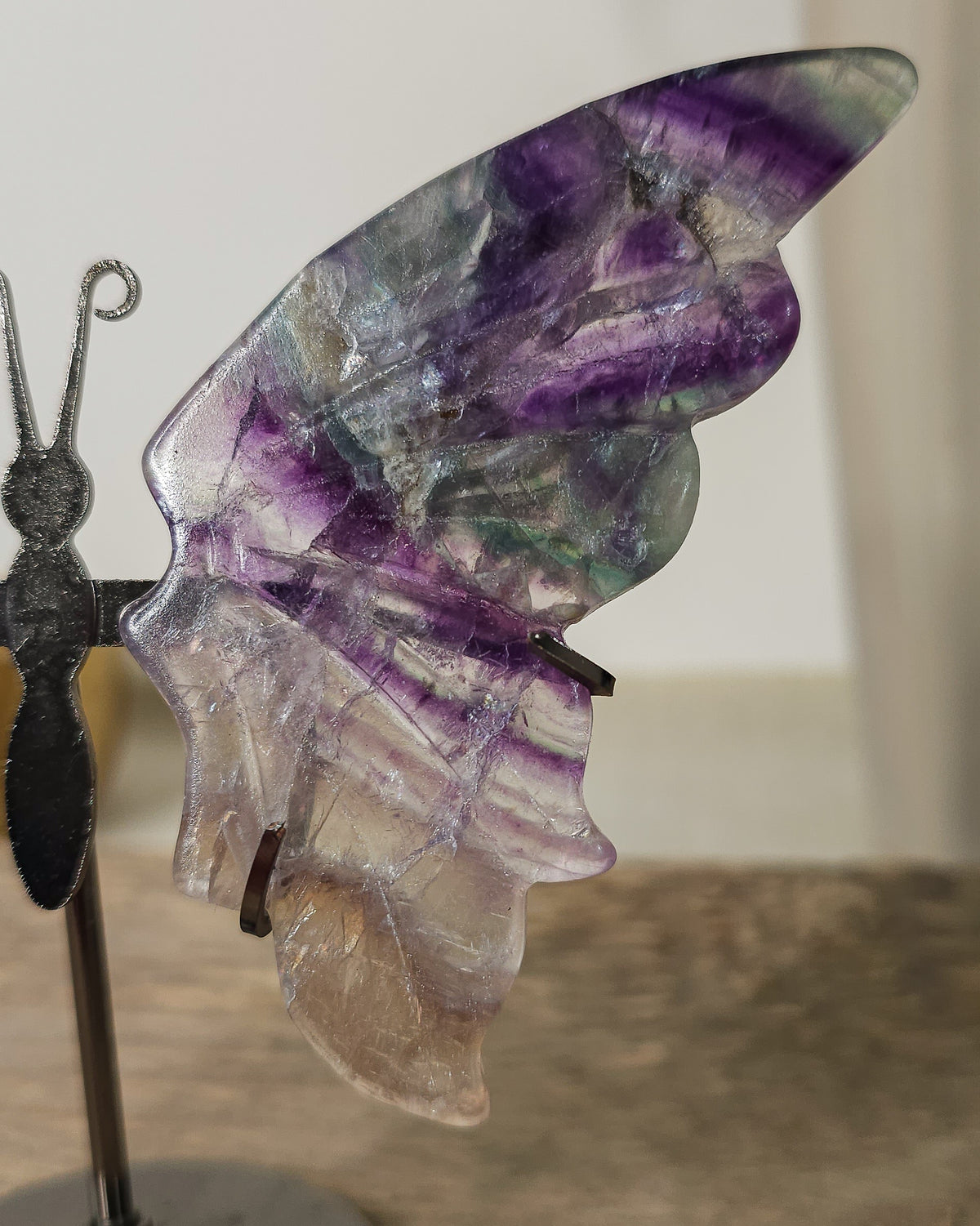 Purple Fluorite butterfly wings on a stand, with translucent layers and natural colour bands. A beautiful crystal display and gift for new beginnings.
