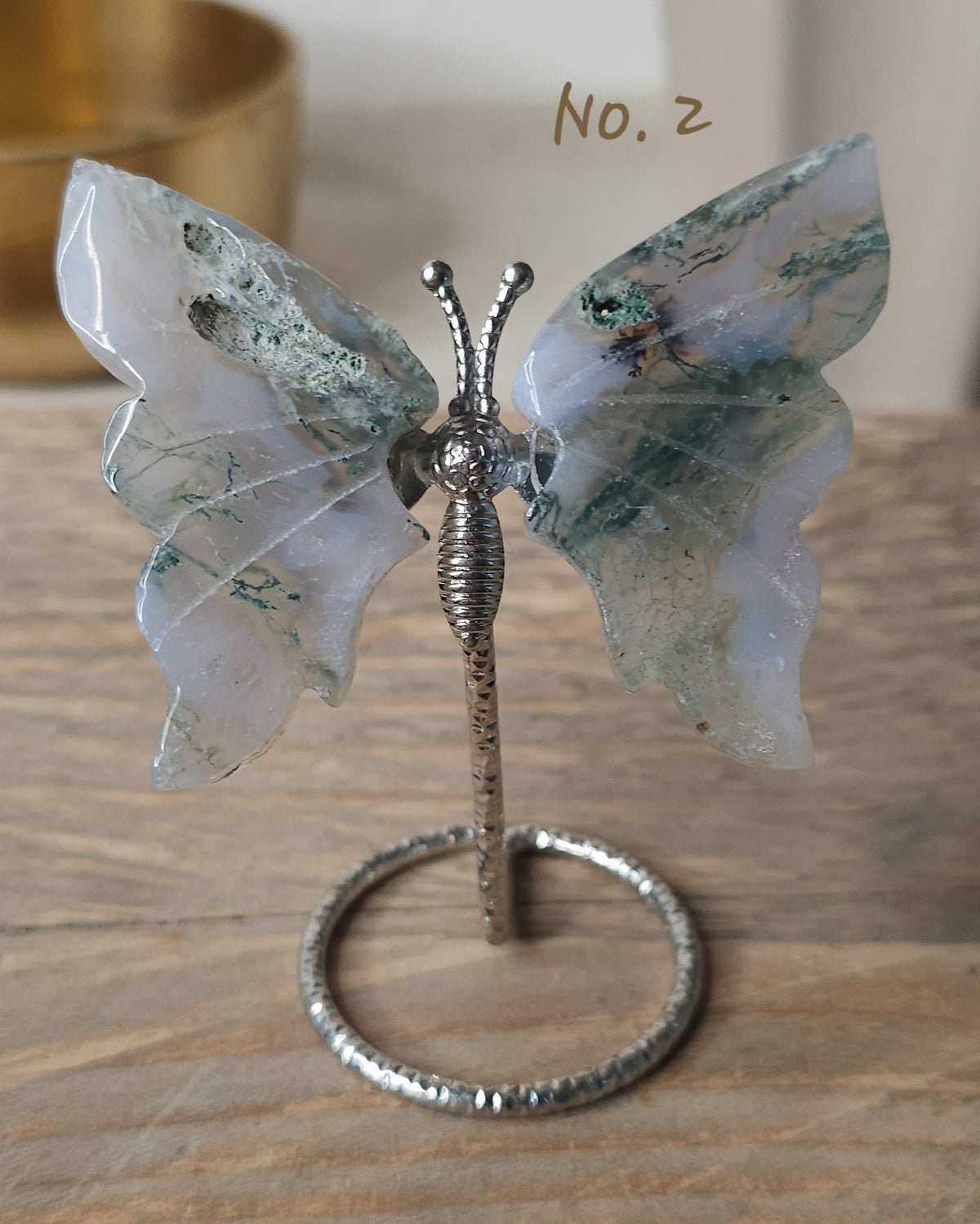 Moss Agate crystal butterfly wings on a stand with natural green moss-like inclusions. A nature-inspired decorative piece and meaningful gift for new beginnings.