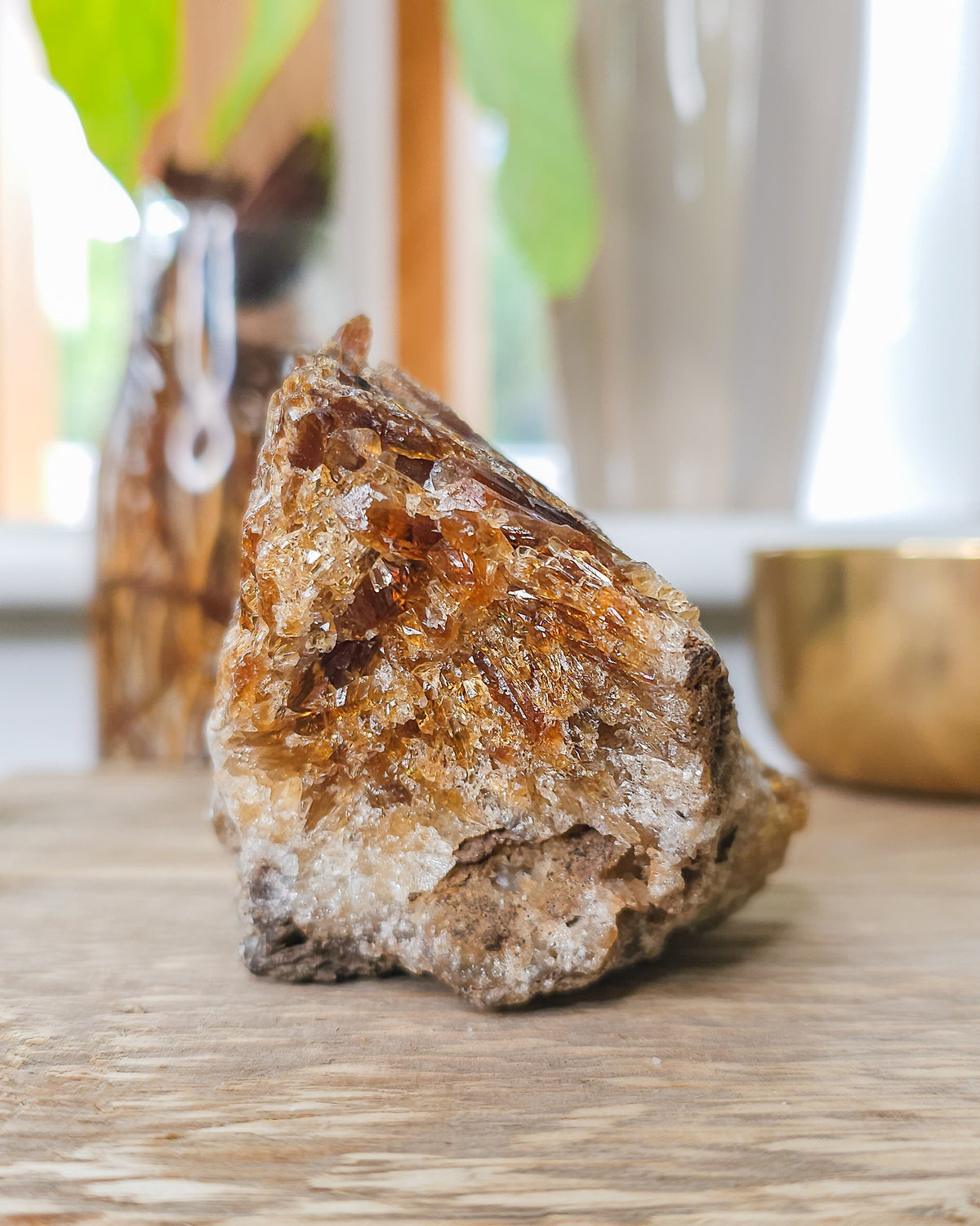 Mineral Amber Calcite specimen on a wooden surface with a blurred indoor background