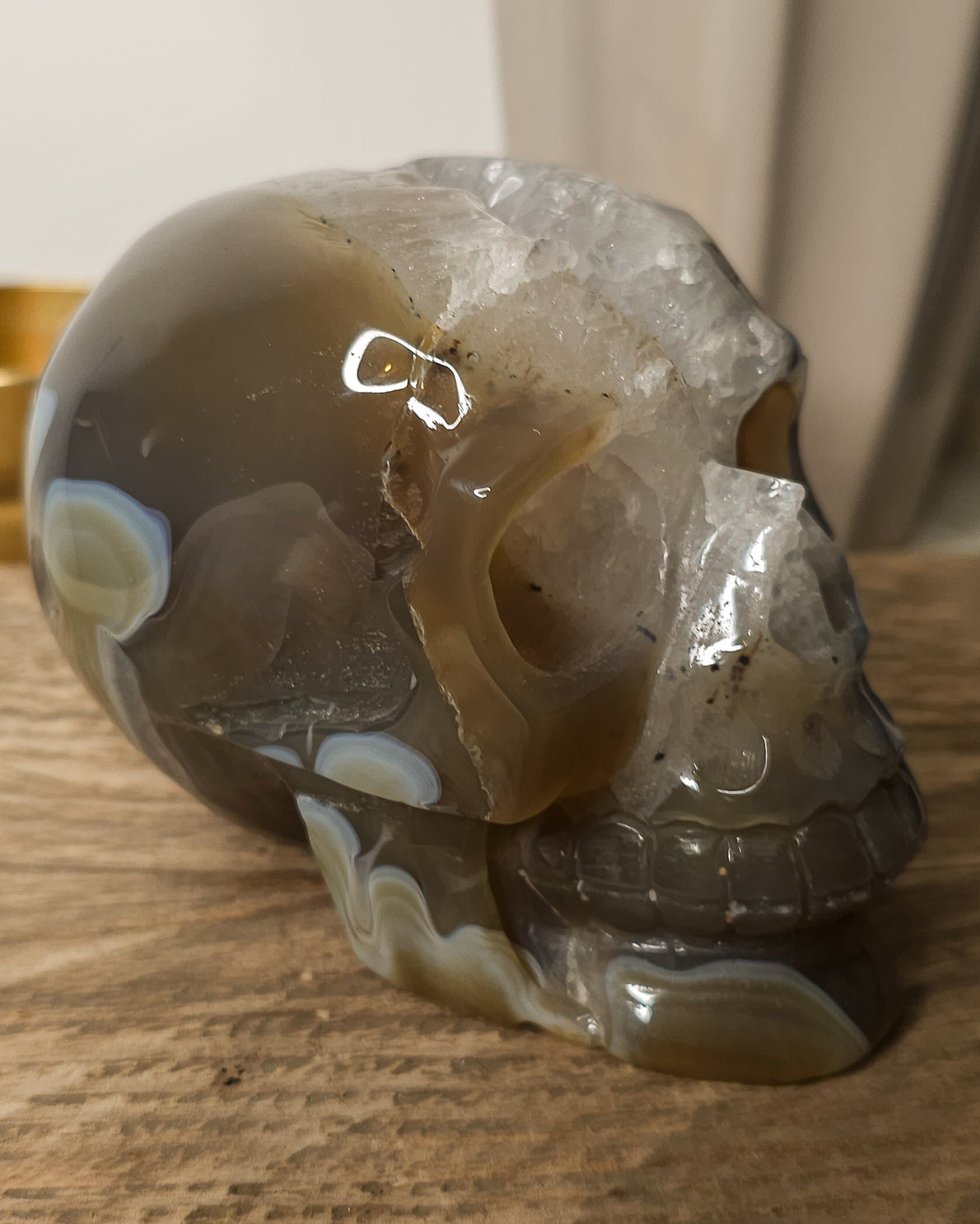 Large Druzy Agate skull carving with smoky grey and brown tones, natural white and pale blue banding, a sparkling quartz druzy cavity and tiny rainbow reflections in the crystals.