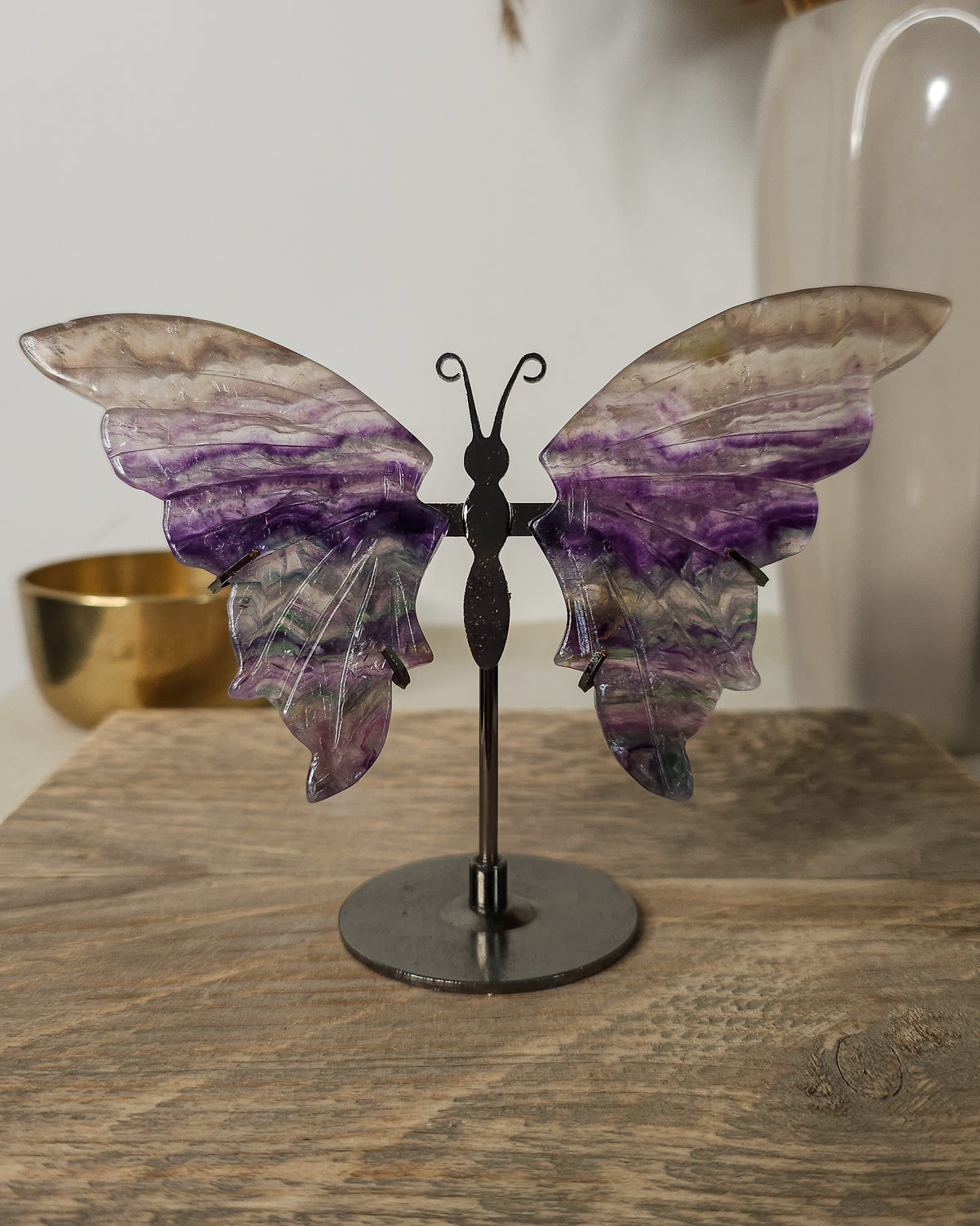 Fluorite crystal butterfly wings on a stand, with purple, green and golden tones. A beautiful display piece and meaningful gift for new beginnings.
