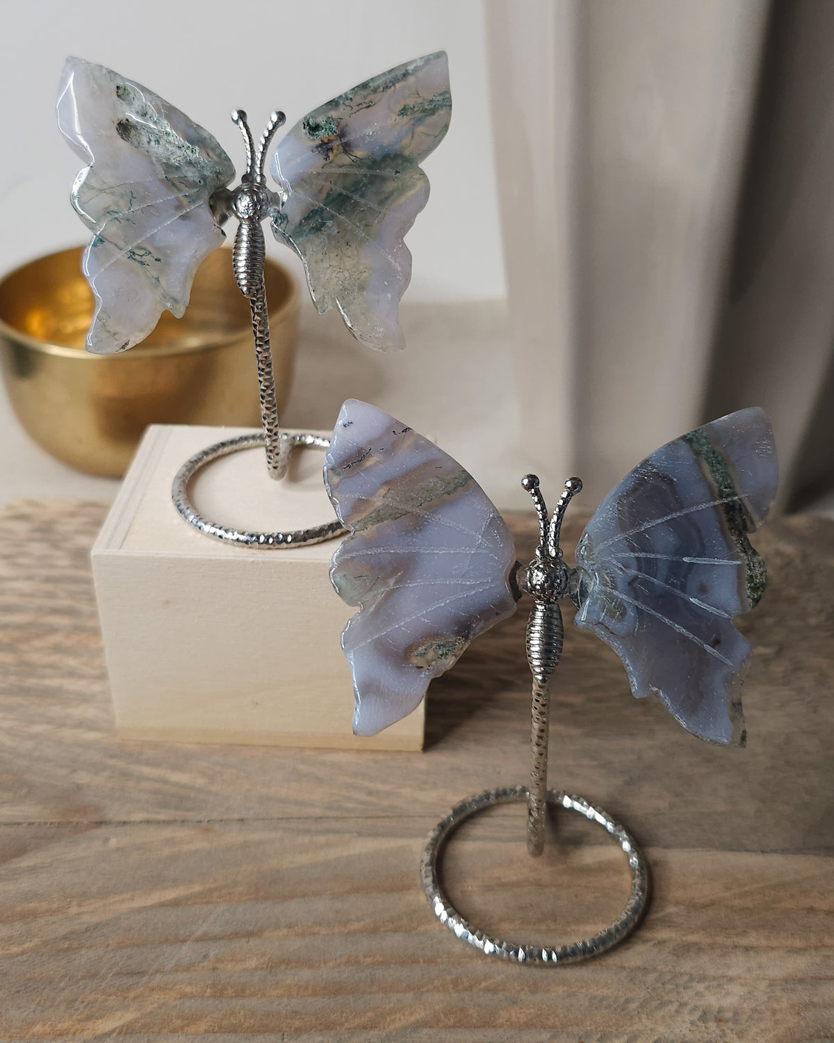 Moss Agate crystal butterfly wings on a stand with natural green moss-like inclusions. A nature-inspired decorative piece and meaningful gift for new beginnings.