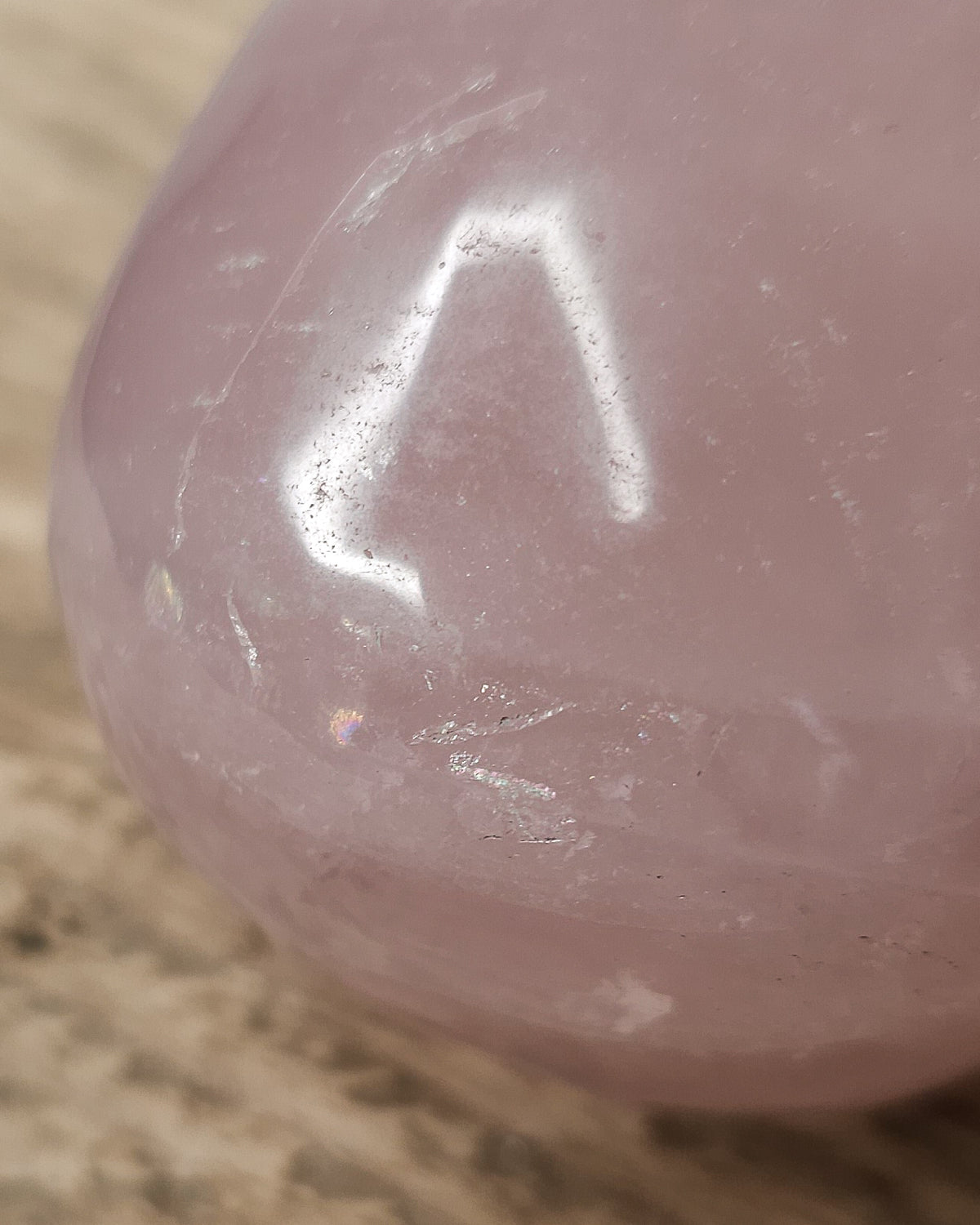 Rose Quartz crystal skull carving with soft pink tones and natural cloudy patterns, polished finish, displayed as a decorative crystal piece.