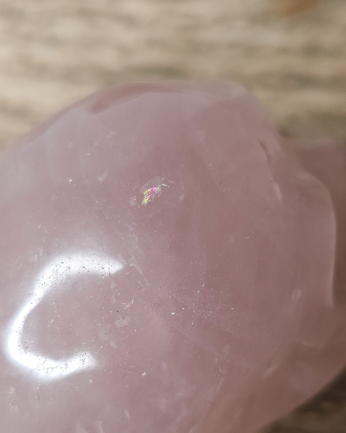Rose Quartz crystal skull carving with soft pink tones and natural cloudy patterns, polished finish, displayed as a decorative crystal piece.