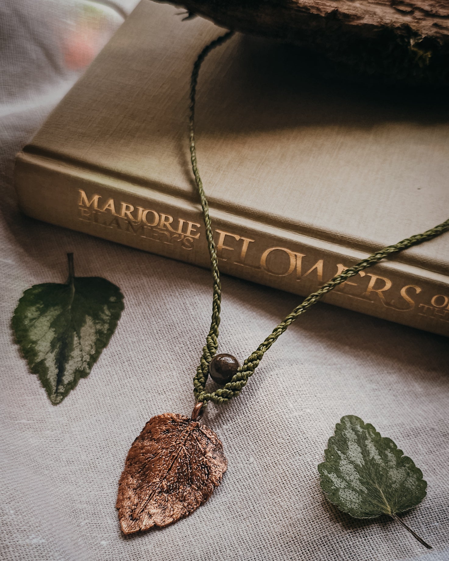 Handcrafted copper electroformed dead nettle leaf necklace with Brown Jasper bead and intricate handwoven micromacramé detailing.