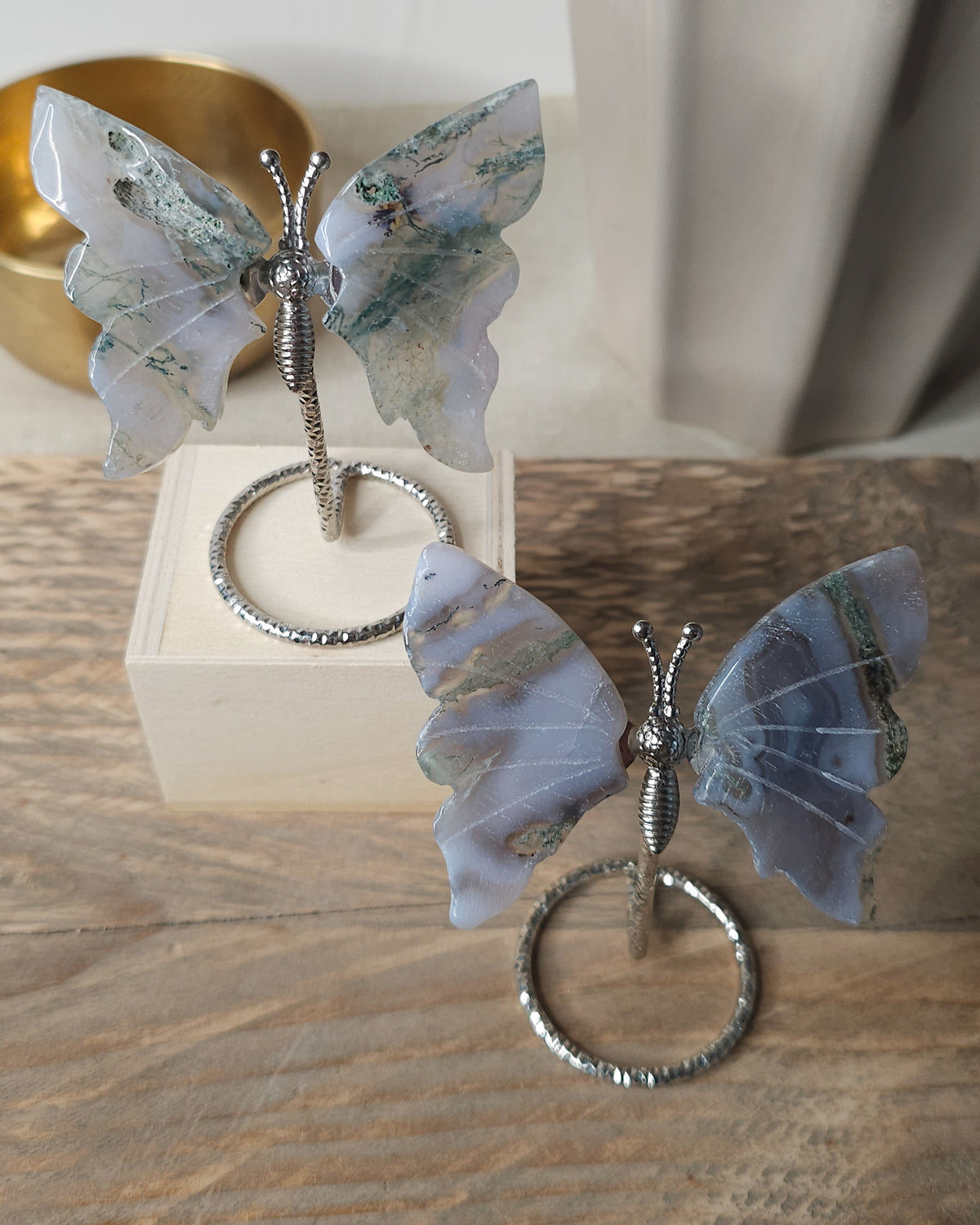 Moss Agate crystal butterfly wings on a stand with natural green moss-like inclusions. A nature-inspired decorative piece and meaningful gift for new beginnings.