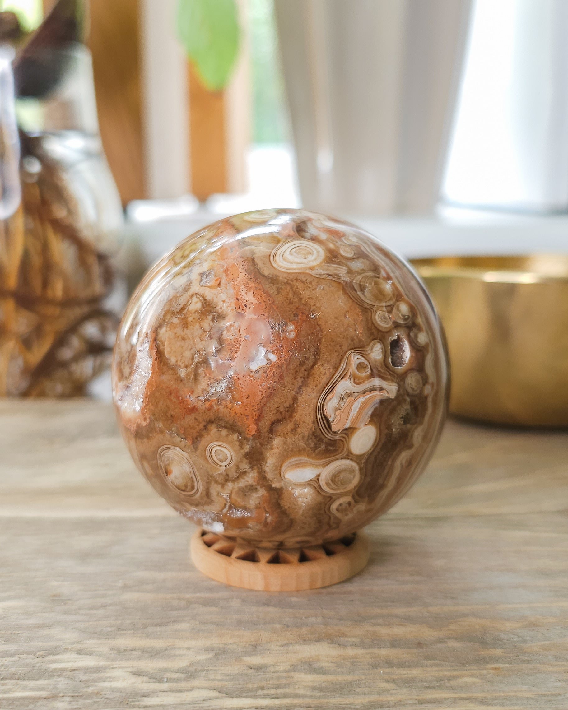 Chocolate Calcite sphere showing natural druzy crystal pocket and layered caramel banding.
