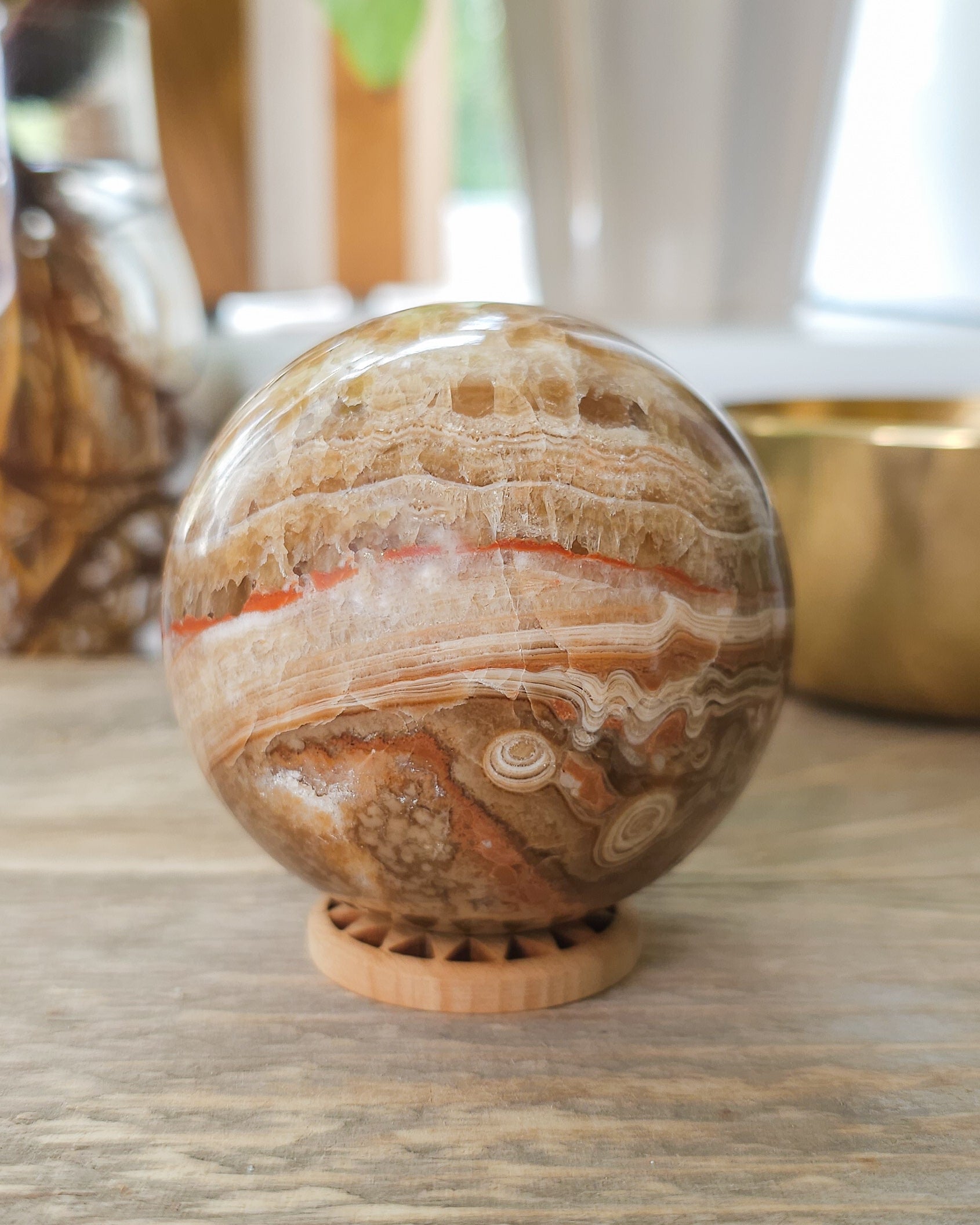 Chocolate Calcite sphere displaying crystal-filled opening and natural brown, cream and honey coloured bands.