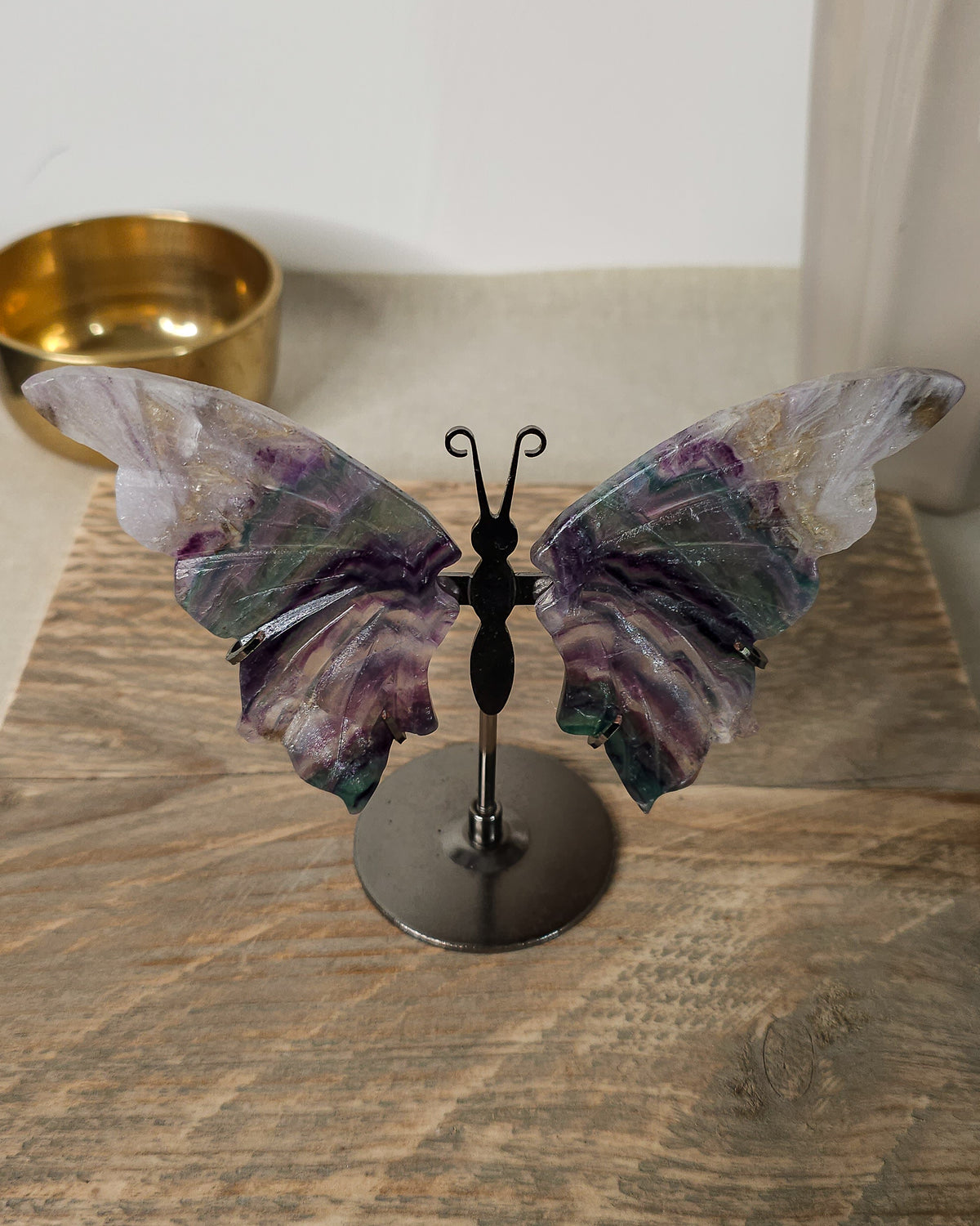 Fluorite butterfly wings on a black metal stand, featuring natural purple, green, clear and golden colour variations.