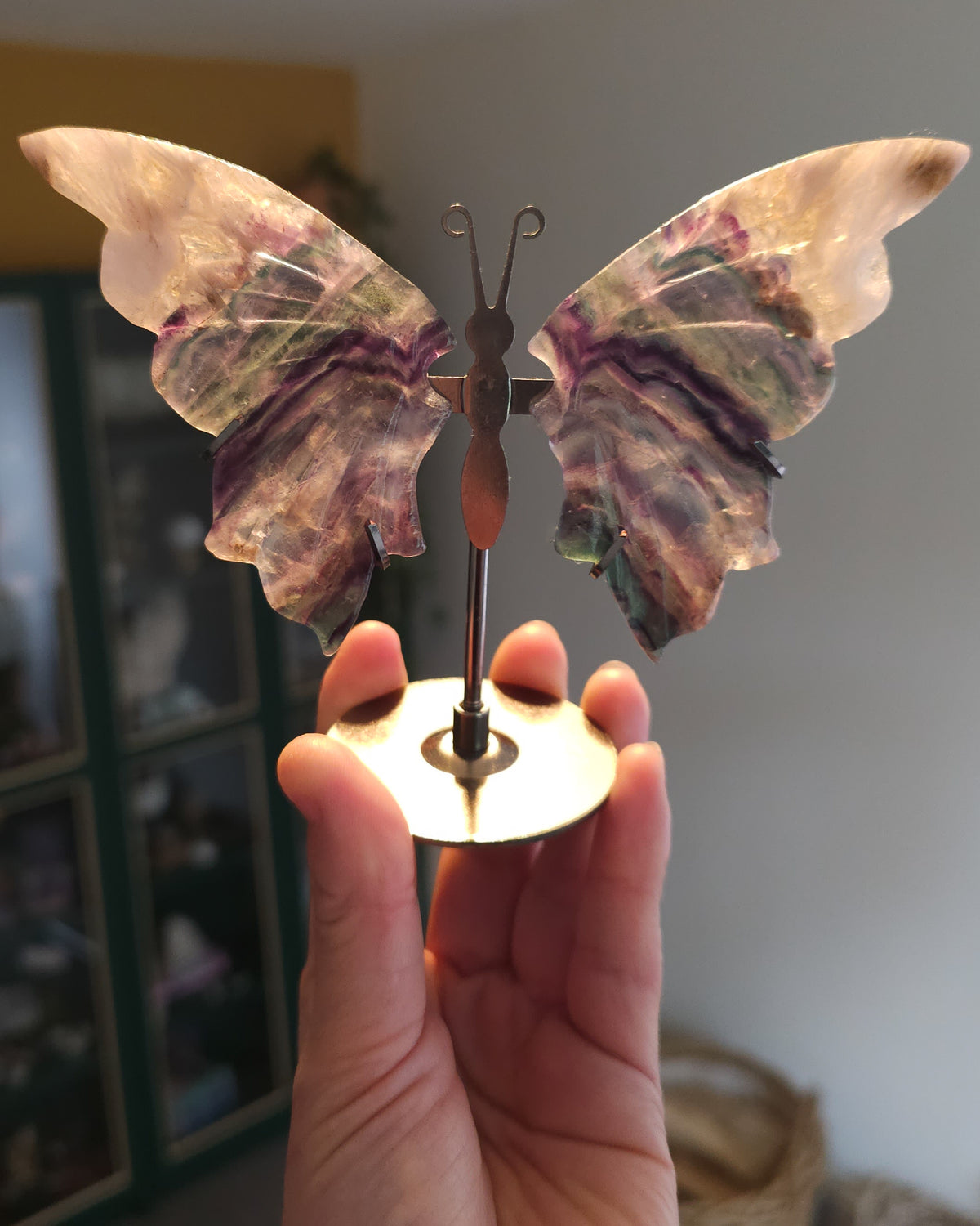 Fluorite butterfly wings on a black metal stand, featuring natural purple, green, clear and golden colour variations.