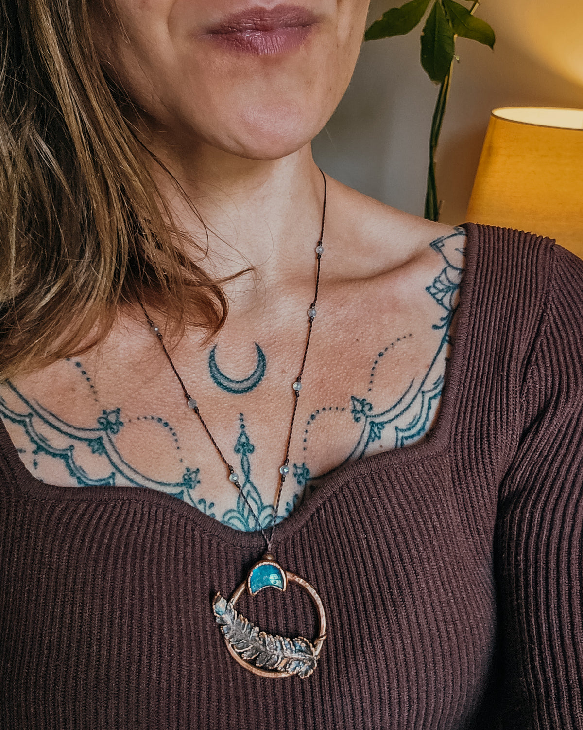 Handcrafted copper fern and Labradorite moon pendant worn on an adjustable cord necklace, showing scale and fit of the Scottish botanical amulet against the neckline.