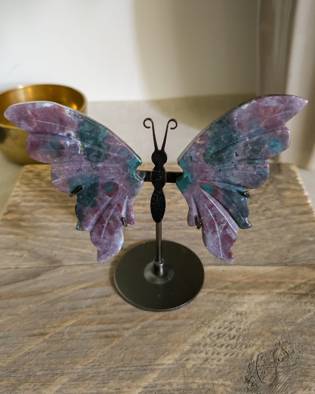 Jasper butterfly wings on a black metal stand, showing natural mauve, pink, green, turquoise and white patterns.