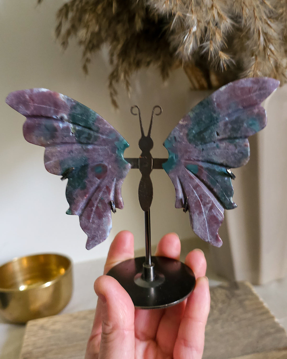 Jasper butterfly wings on a black metal stand, showing natural mauve, pink, green, turquoise and white patterns.