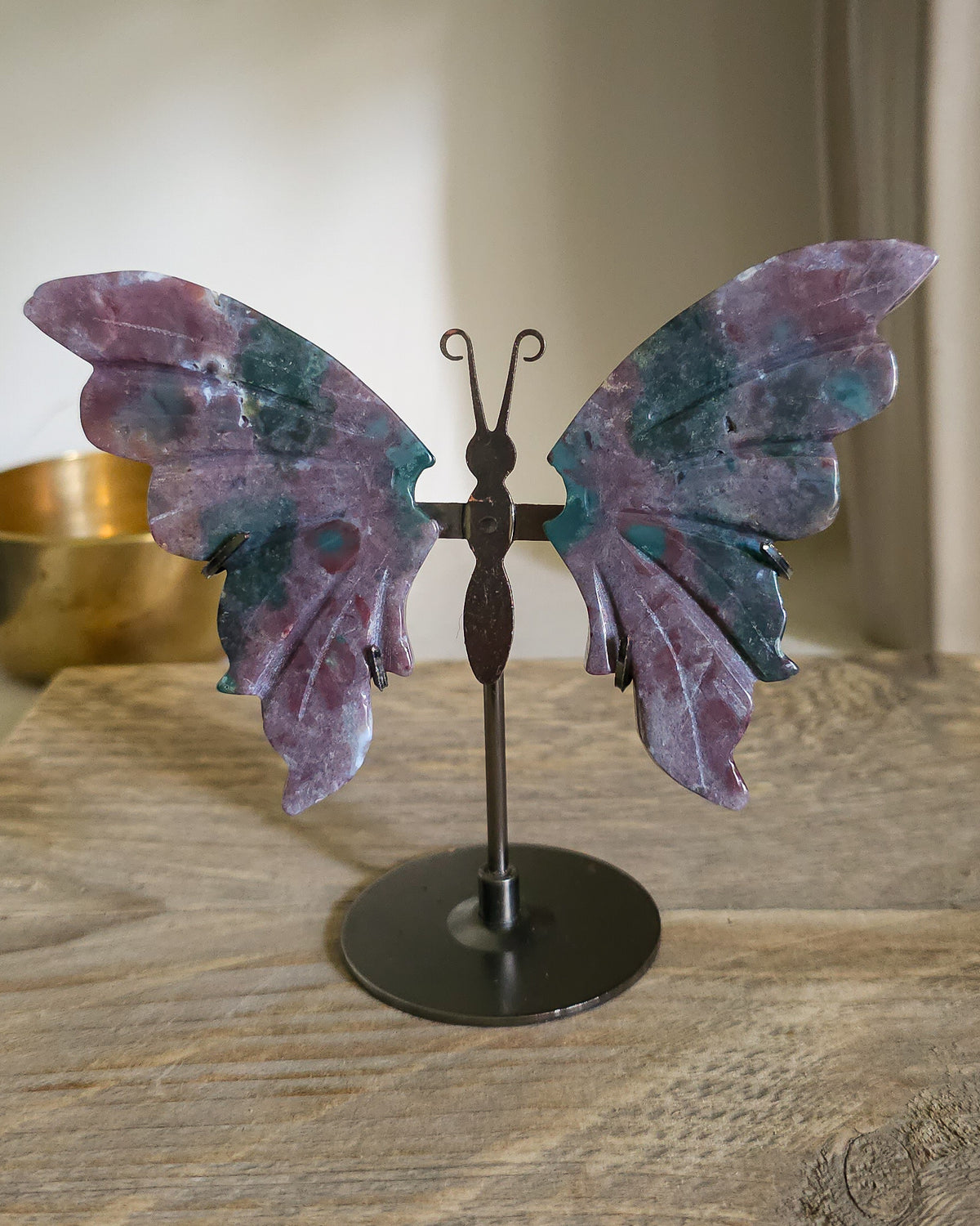 Jasper butterfly wings on a black metal stand, showing natural mauve, pink, green, turquoise and white patterns.