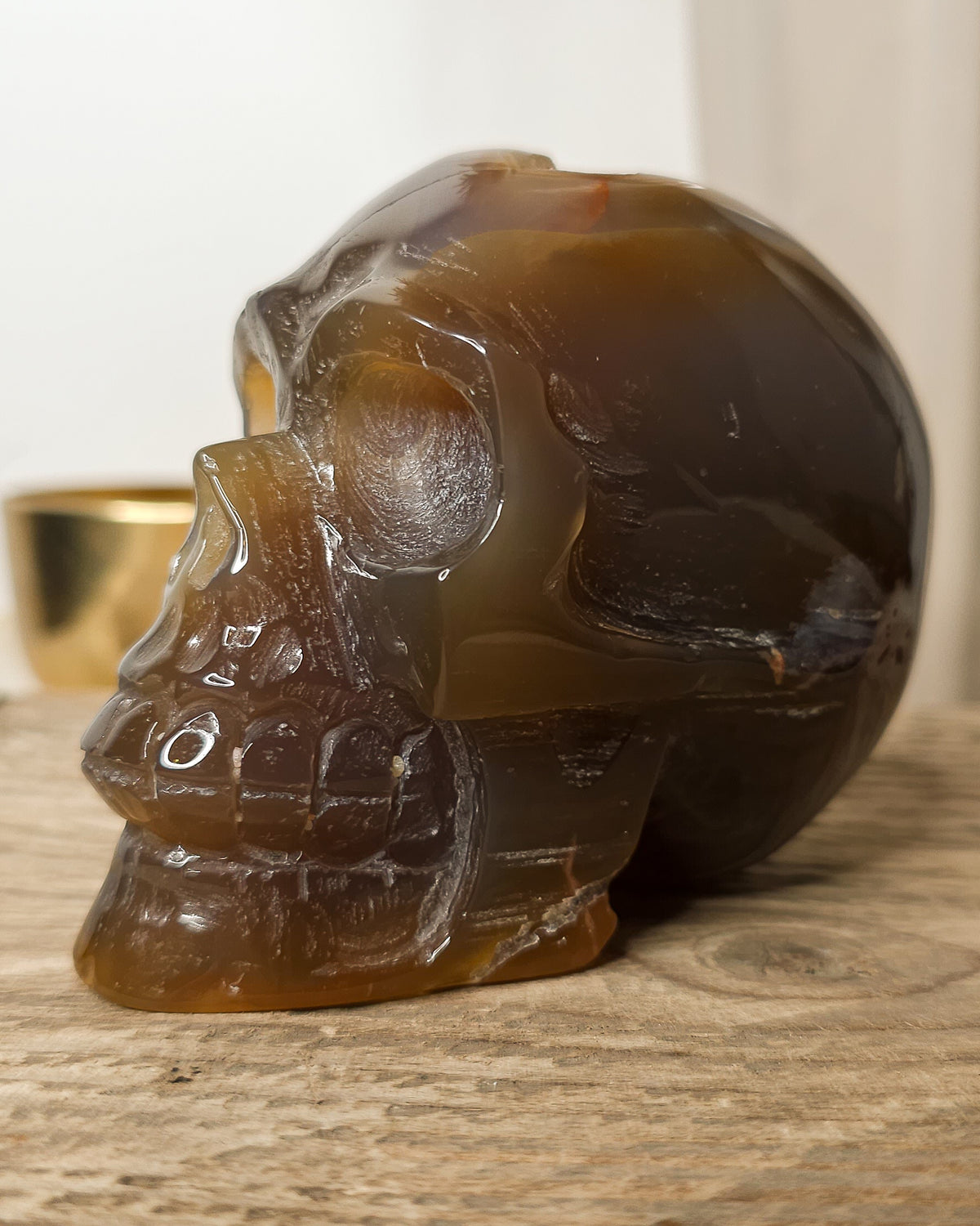Smoky Agate skull carving with natural brown, charcoal grey and amber tones, translucent banding and a sparkling druzy crystal cavity on the back.
