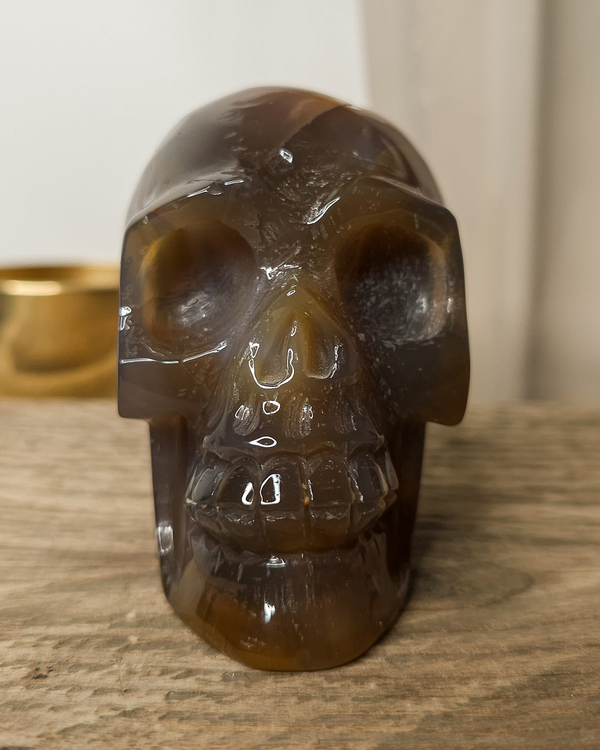 Smoky Agate skull carving with natural brown, charcoal grey and amber tones, translucent banding and a sparkling druzy crystal cavity on the back.