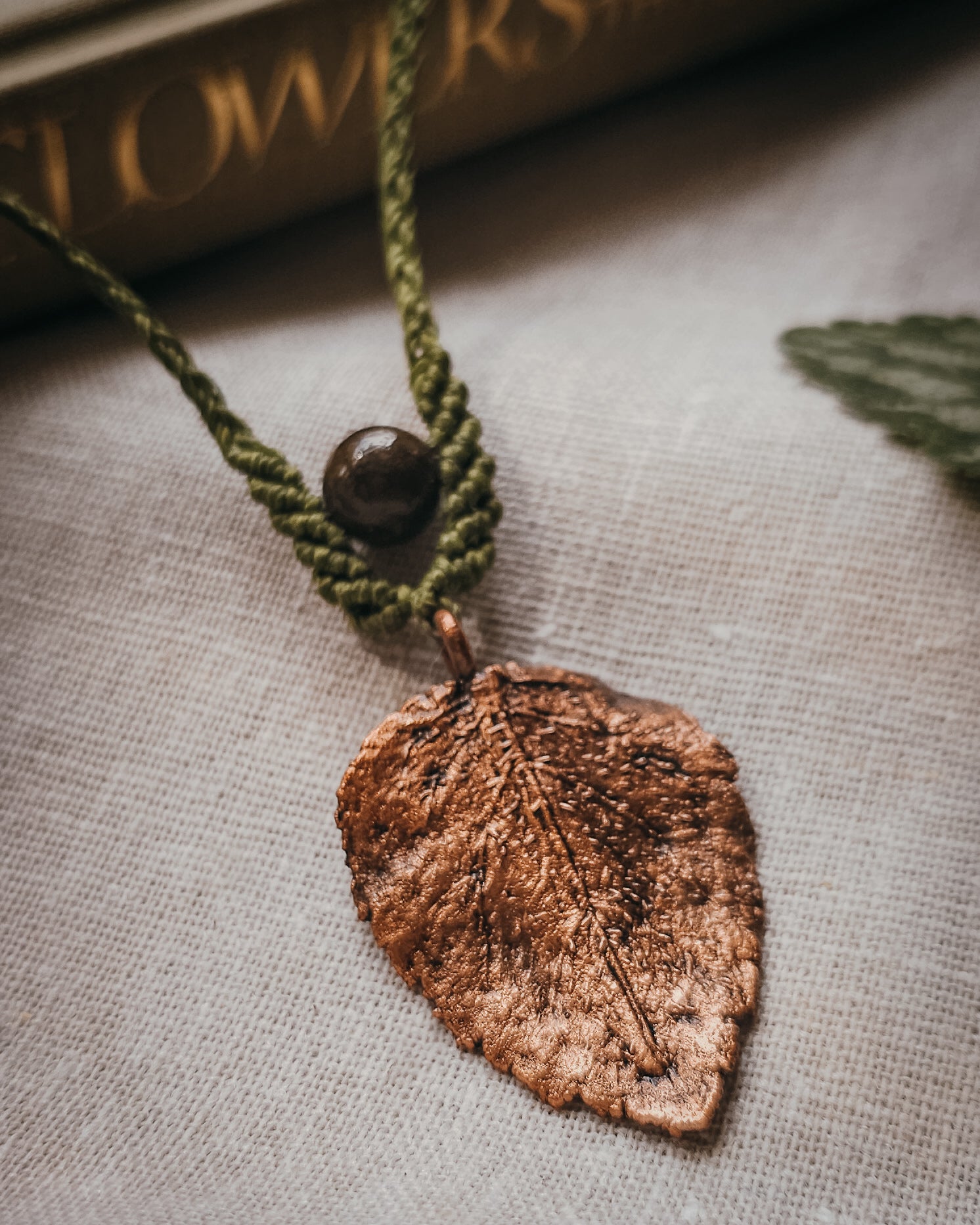 Close-up of Nettle Spirit Scottish Botanical Amulet showing the intricate leaf veins captured in copper and natural Brown Jasper bead.