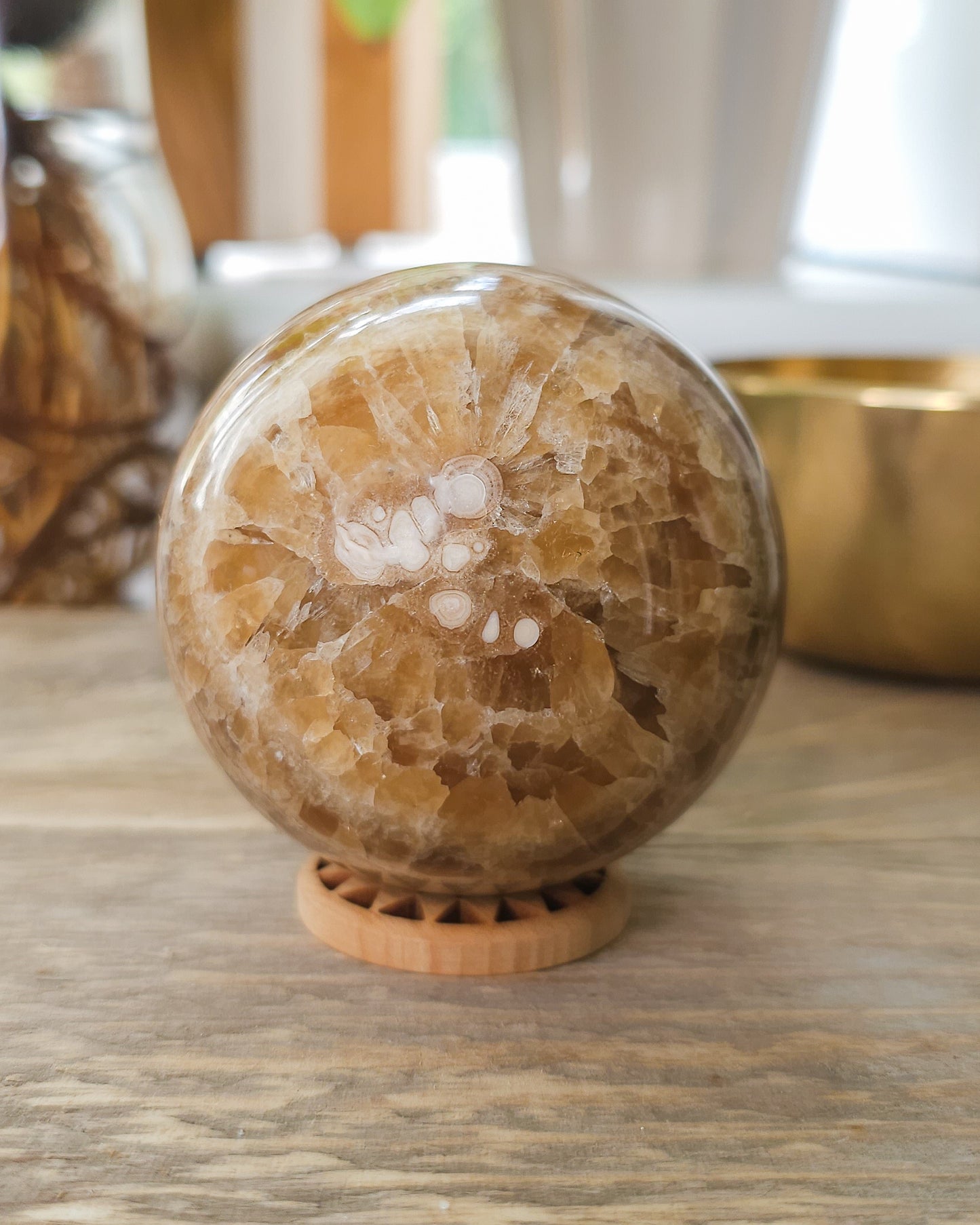 Chocolate Calcite sphere displaying crystal-filled opening and natural brown, cream and honey coloured bands.