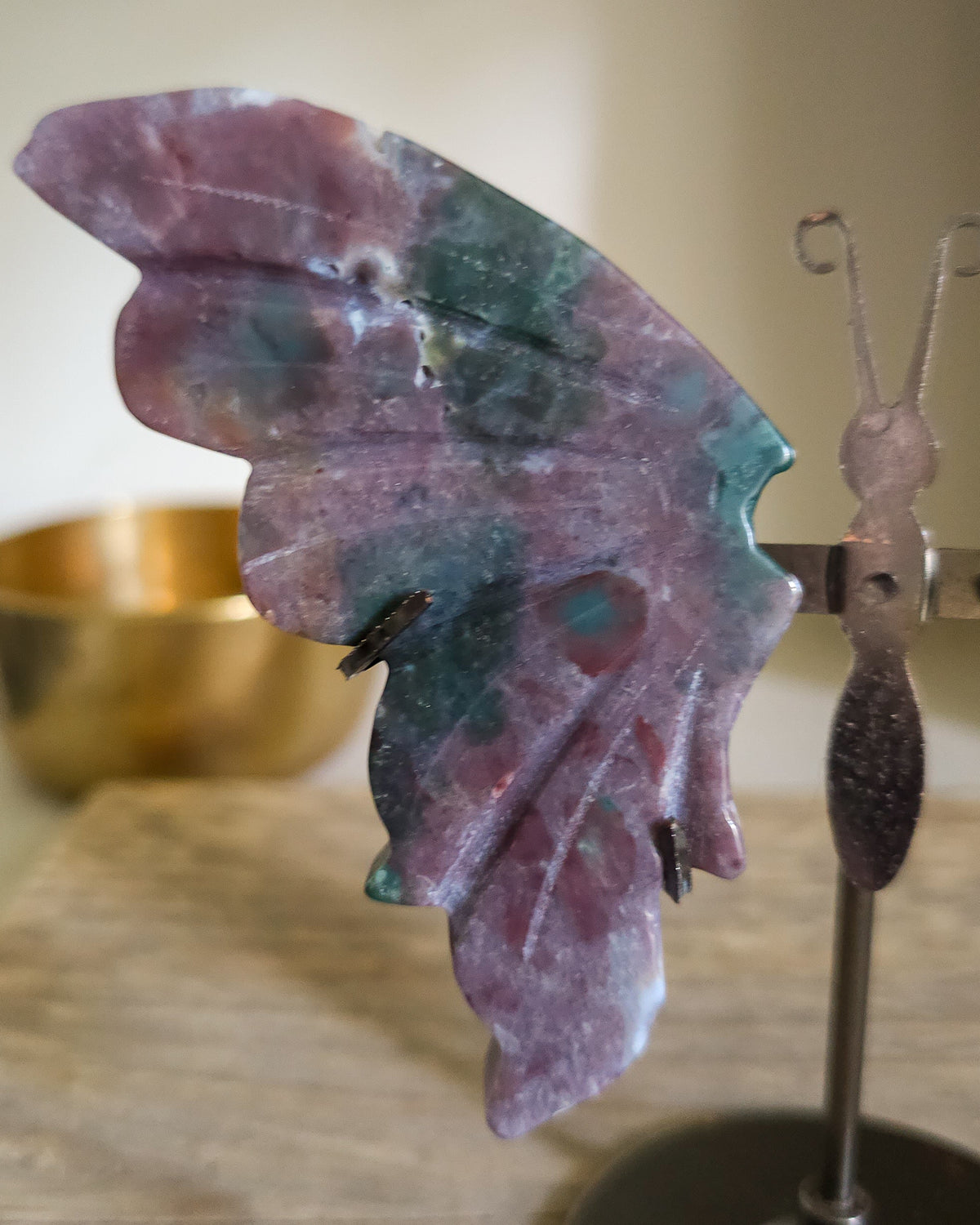Jasper butterfly wings on a black metal stand, showing natural mauve, pink, green, turquoise and white patterns.