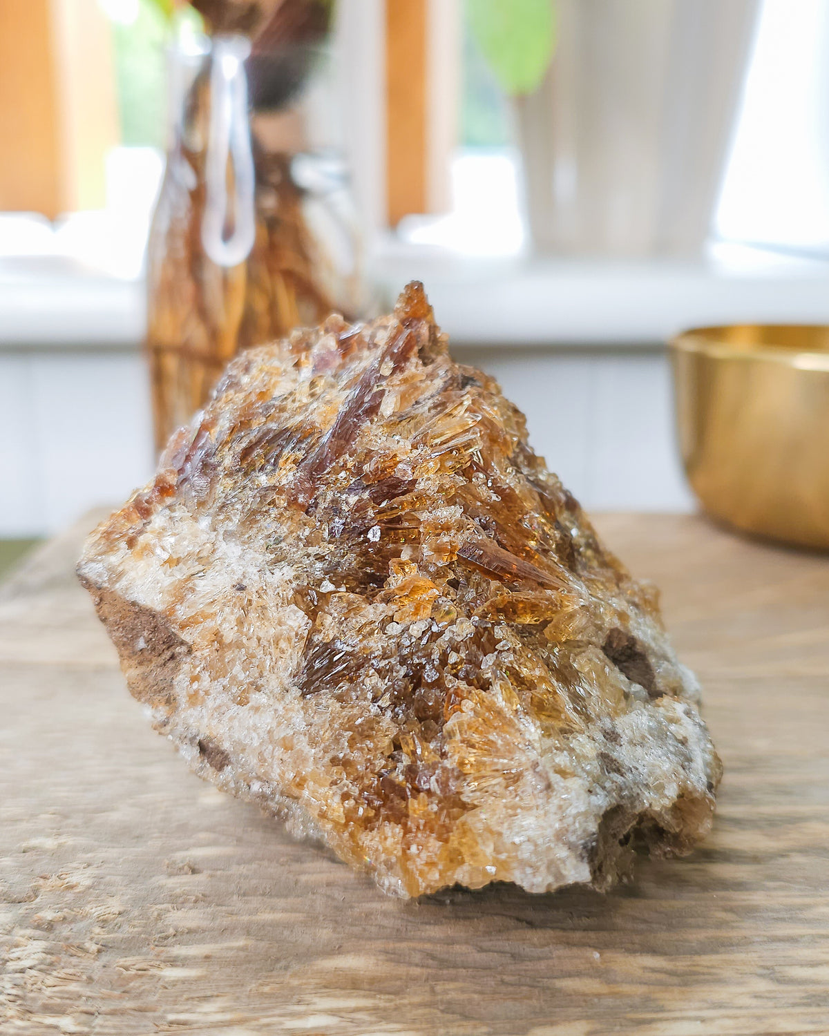 Mineral Amber Calcite specimen on a wooden surface with a blurred indoor background