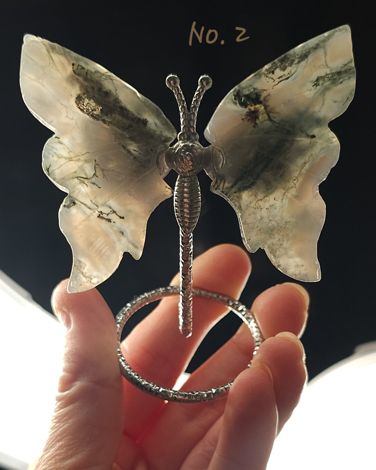 Moss Agate crystal butterfly wings on a stand with natural green moss-like inclusions. A nature-inspired decorative piece and meaningful gift for new beginnings.