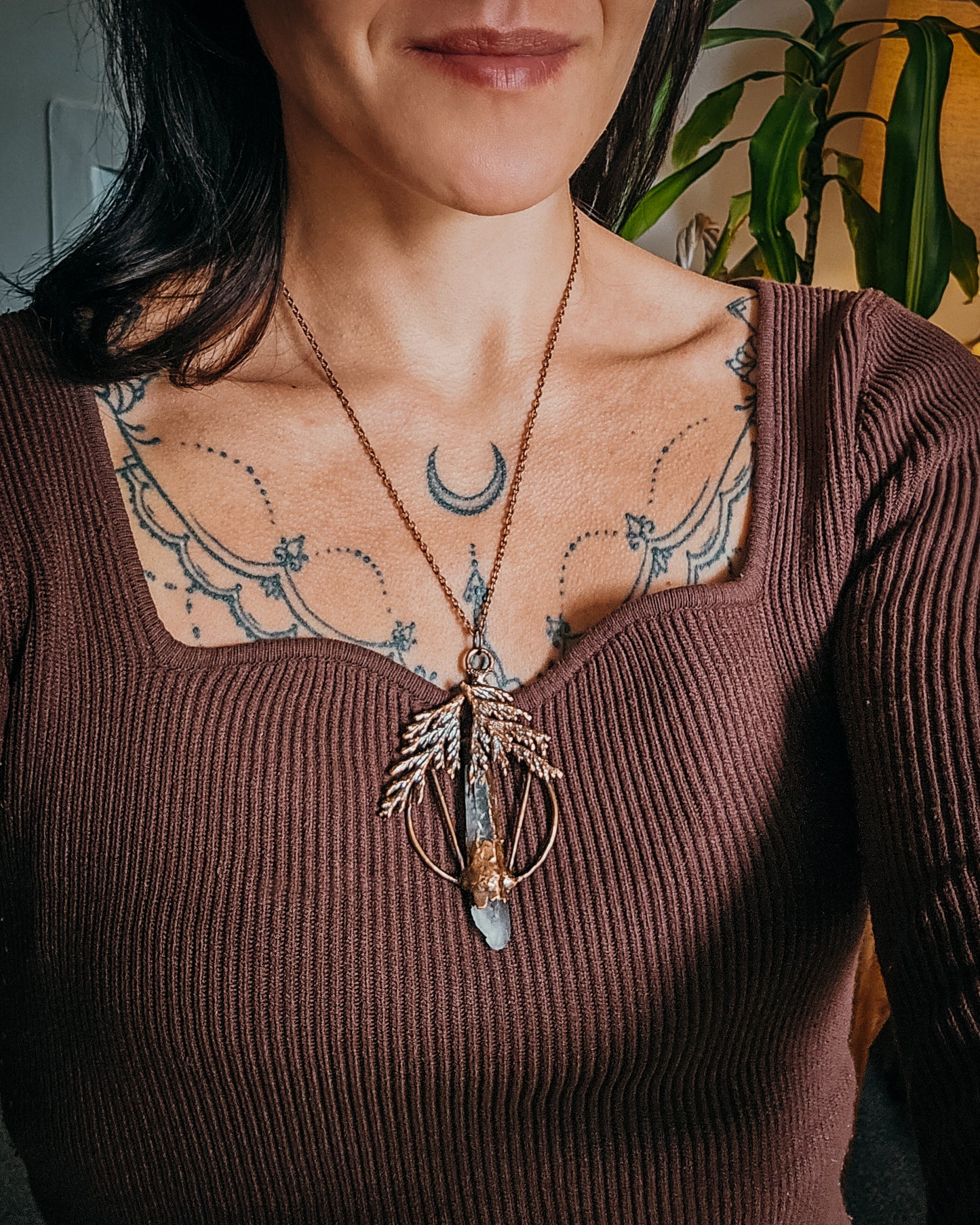 Person wearing a Handmade Copper electroformed Necklace with a cypress and clear Quartz crystal pendant 
