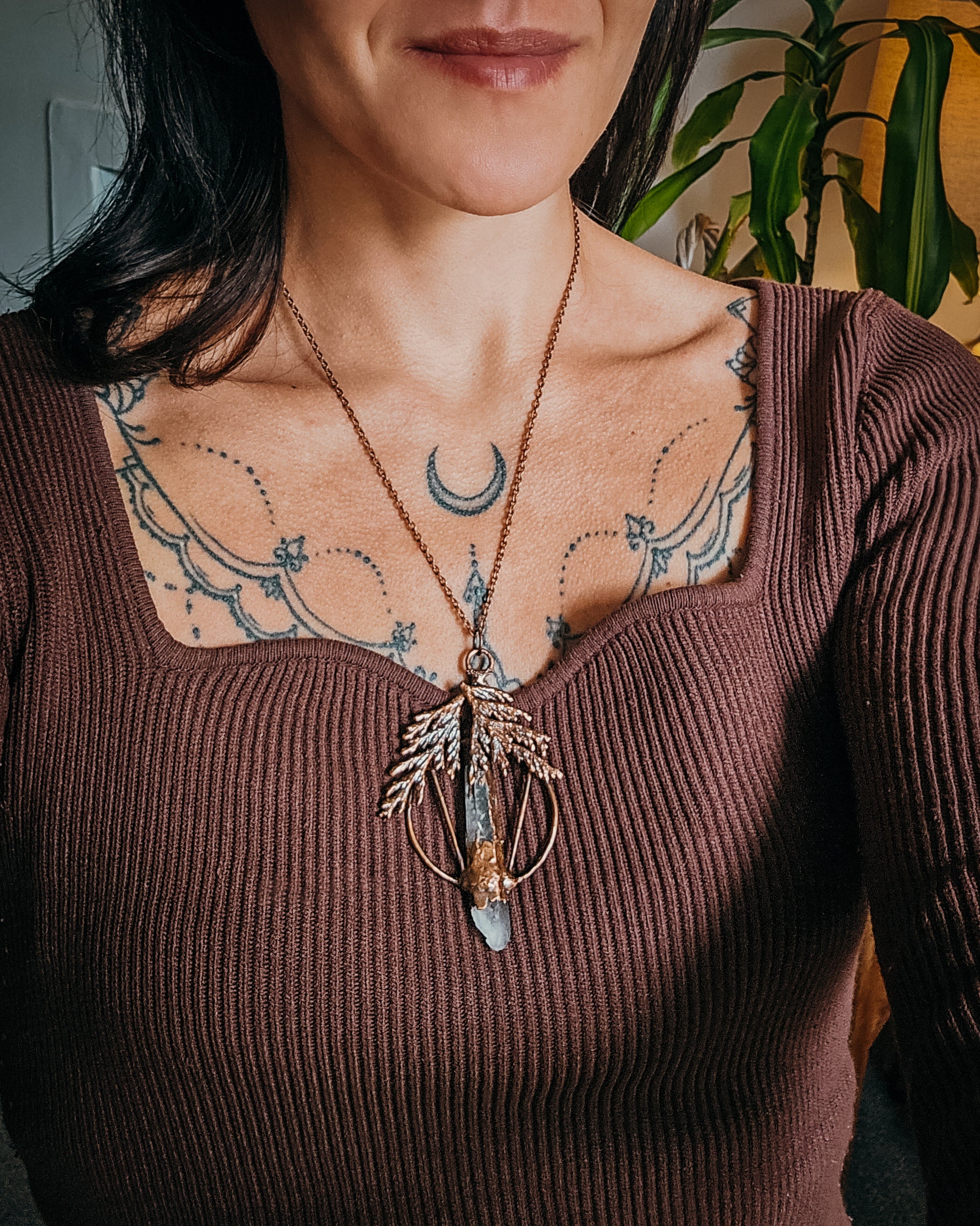 Person wearing a Handmade Copper electroformed Necklace with a cypress and clear Quartz crystal pendant 