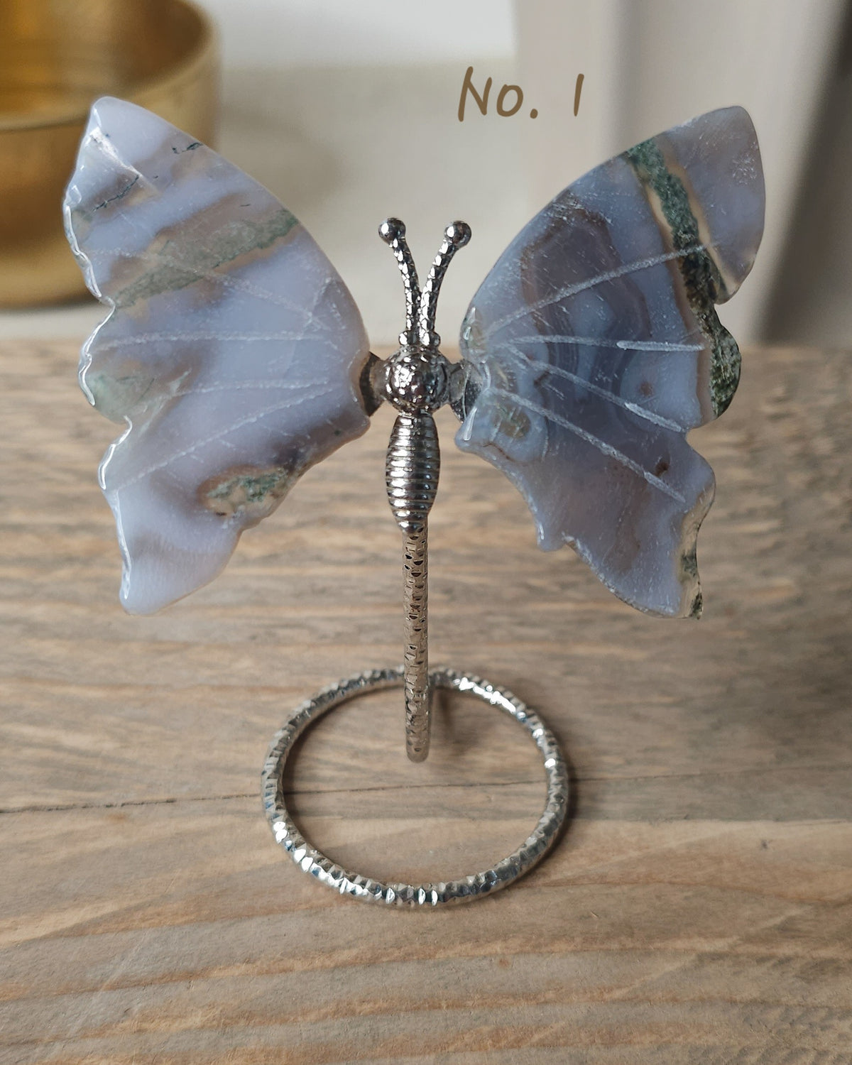 Moss Agate crystal butterfly wings on a stand with natural green moss-like inclusions. A nature-inspired decorative piece and meaningful gift for new beginnings.