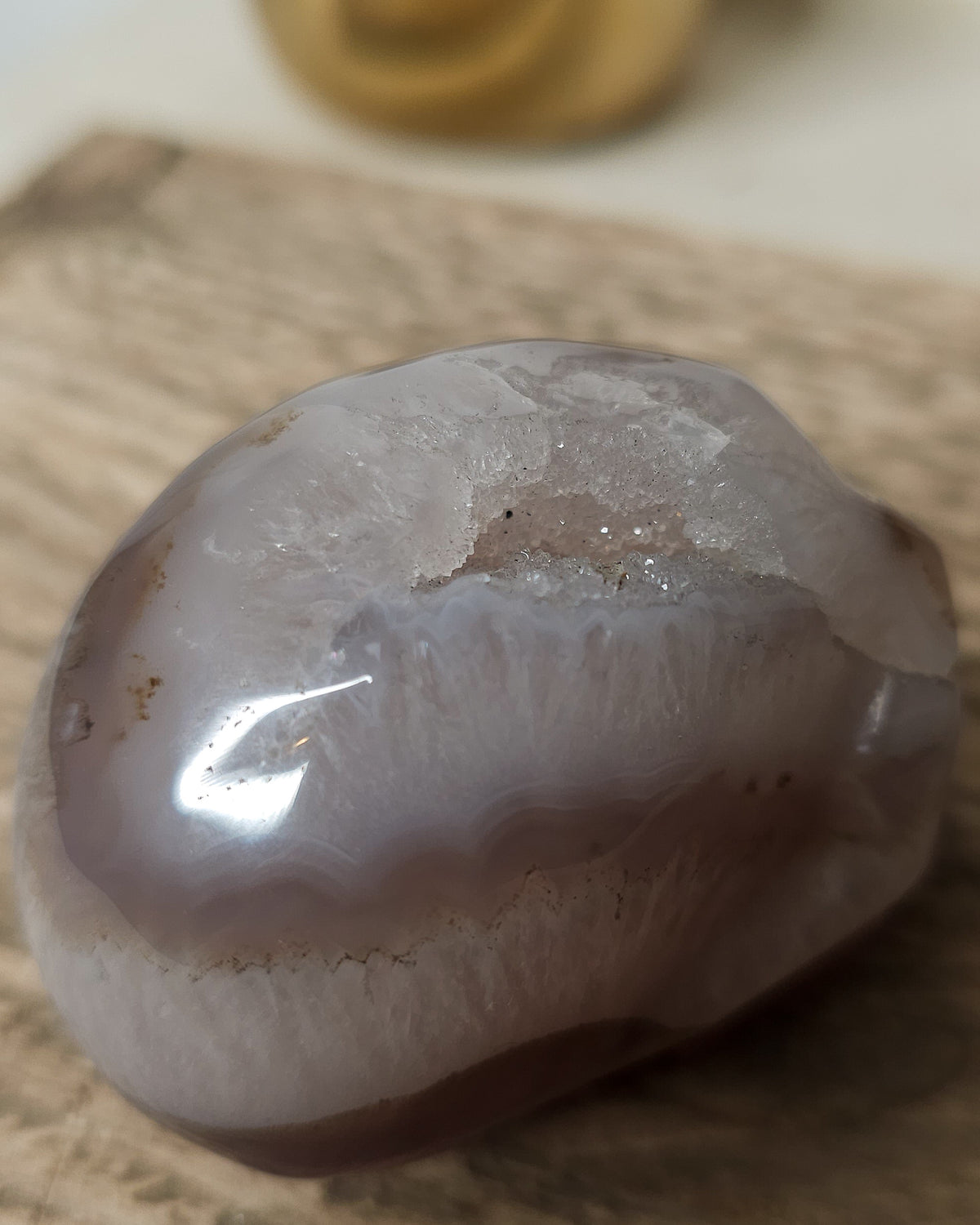 Druzy Agate crystal skull carving with translucent grey and lavender bands, deep purple areas, natural brown inclusions and a sparkling druzy crystal cavity on top.