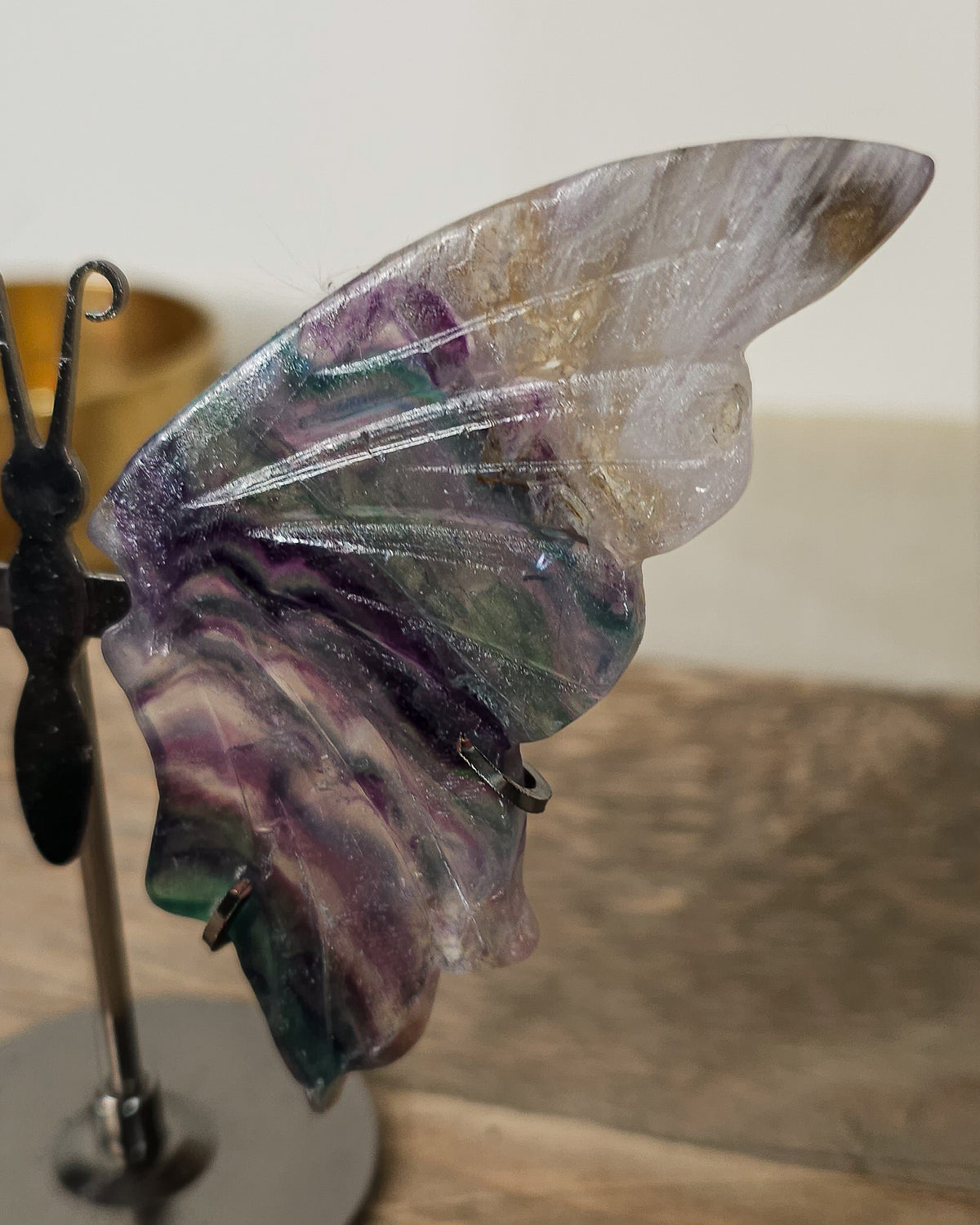 Fluorite butterfly wings on a black metal stand, featuring natural purple, green, clear and golden colour variations.