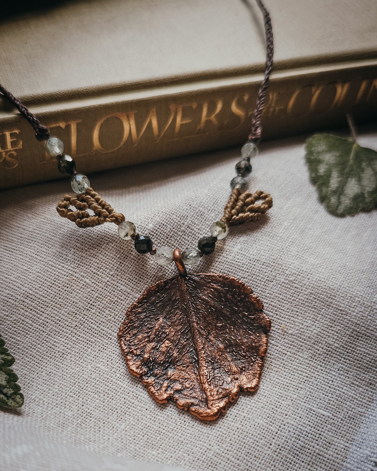 Close-up of Nettle Spirit Scottish Botanical Amulet showing the intricate leaf veins captured in copper and natural Prehnite with Epidote beads.